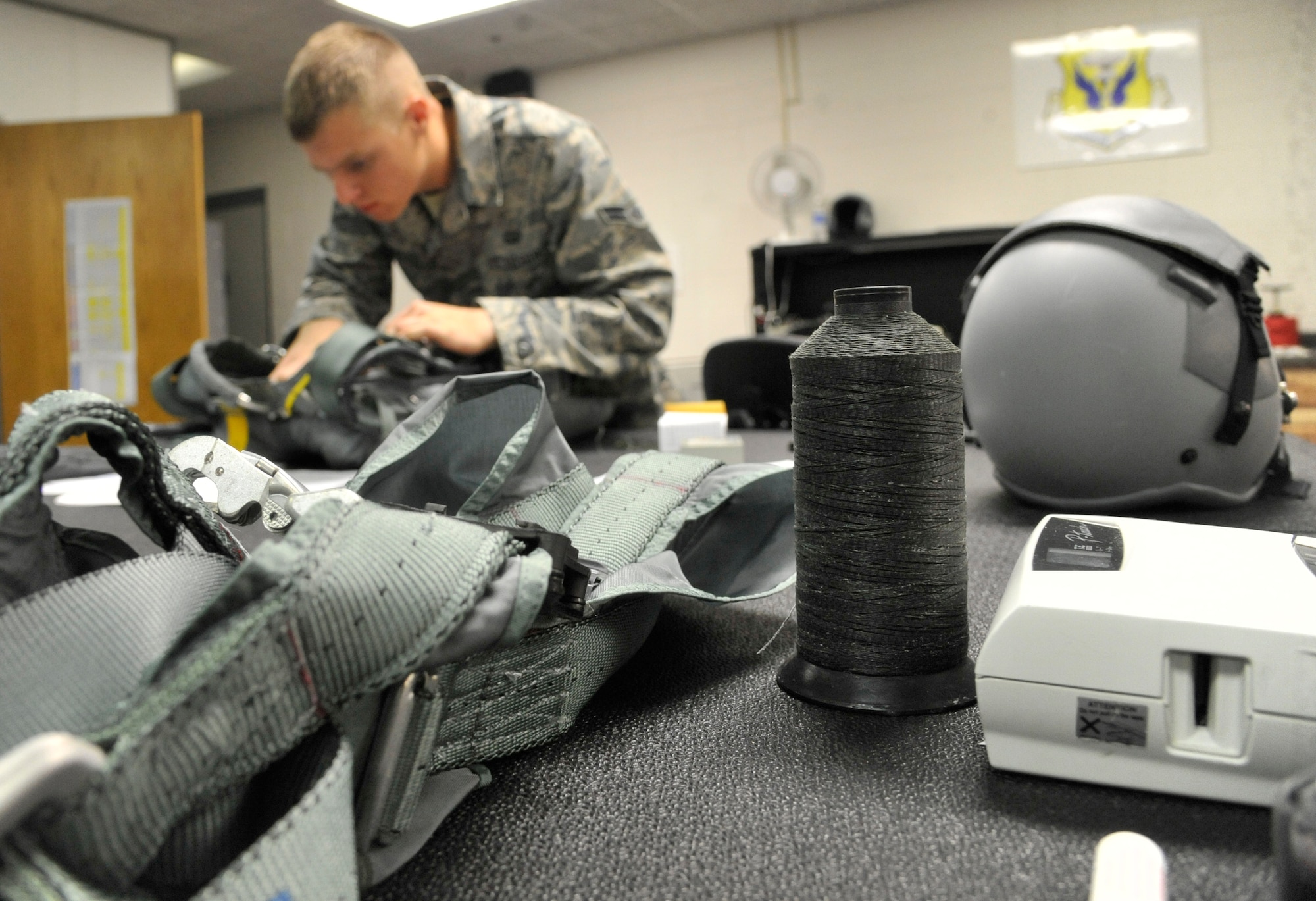 U.S. Air Force Airman 1st Class William Butler, 509th Operations Support Squadron aircrew flight equipment technician, inspects a back automatic-22 parachute at Whiteman Air Force Base, Mo., Oct. 9, 2013. AFE technicians perform daily inspections of equipment to ensure it is functioning properly.. (U.S. Air Force photo by Airman 1st Class Keenan Berry/Released)
