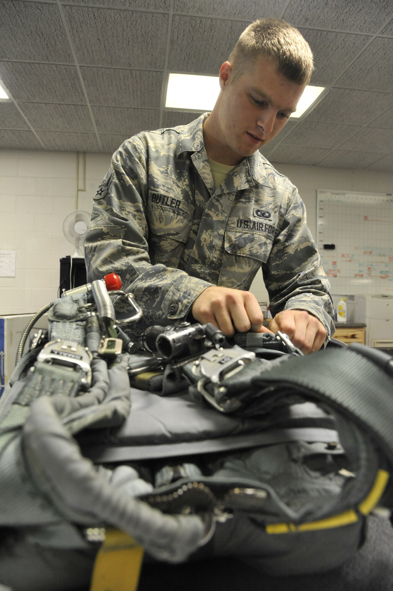 U.S. Air Force Airman 1st Class William Butler, 509th Operations Support Squadron aircrew flight equipment technician, inspects the pockets of a back automatic-22 parachute to ensure the presence of strobe lights, Whiteman Air Force Base, Mo., Oct. 9, 2013. Strobe lights are used to signal for rescue once the pilot has ejected and is awaiting extraction. (U.S. Air Force photo by Airman 1st Class Keenan Berry/Released)