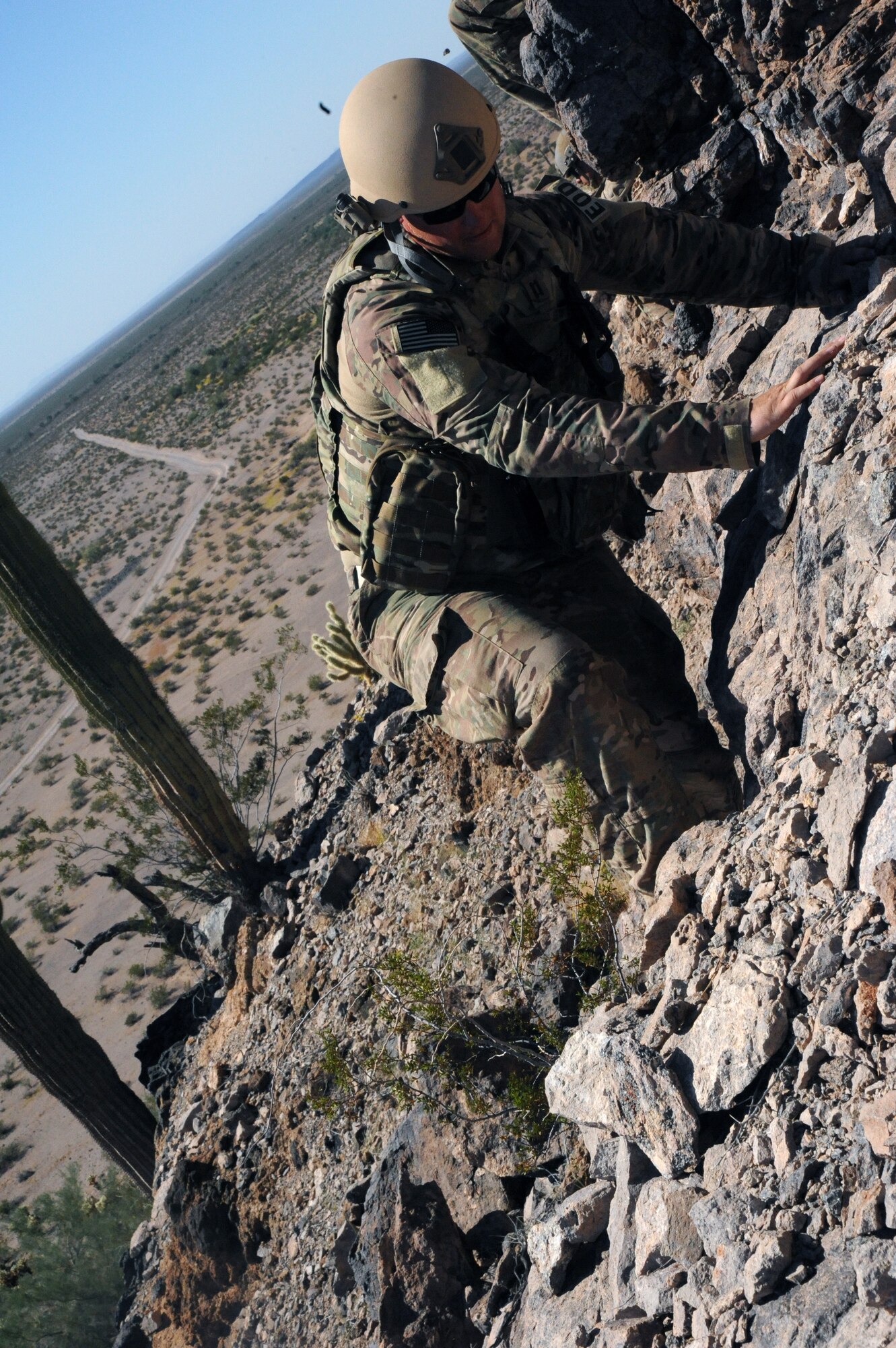 Capt. Justin Schultz, 56th CES EOD team commander, scales a steep hillside to uncover a hidden weapon cache. Multiple scenarios were conducted throughout the four-day training. (U.S. Air Force photo/Airman 1st Class Pedro Mota)