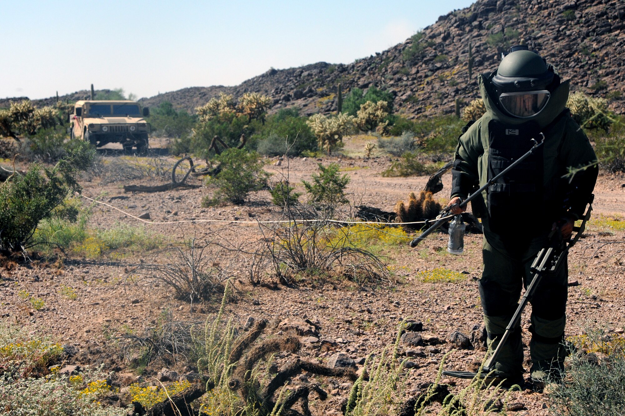 Staff Sgt. Adam Clement, 56th CES EOD team leader, clears a path to place a disruption charge on an IED during the training. In situations where the EOD robot isn’t able to cover the terrain, EOD members must proceed on foot. (U.S. Air Force photo/Airman 1st Class Pedro Mota)