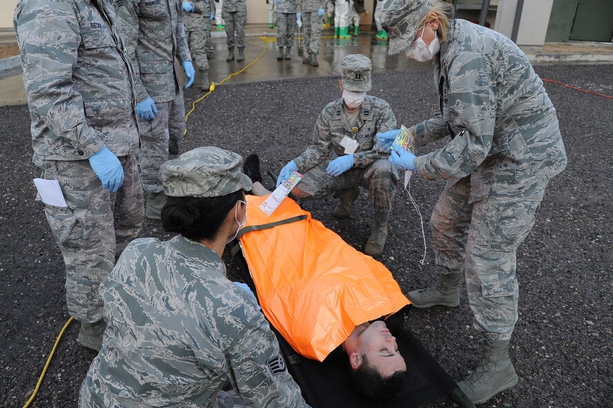 Members of the 56th MDOS place a thermal blanket on a patient during the exercise. (U.S. Air Force photo/Airman 1st Class James Hensley)
