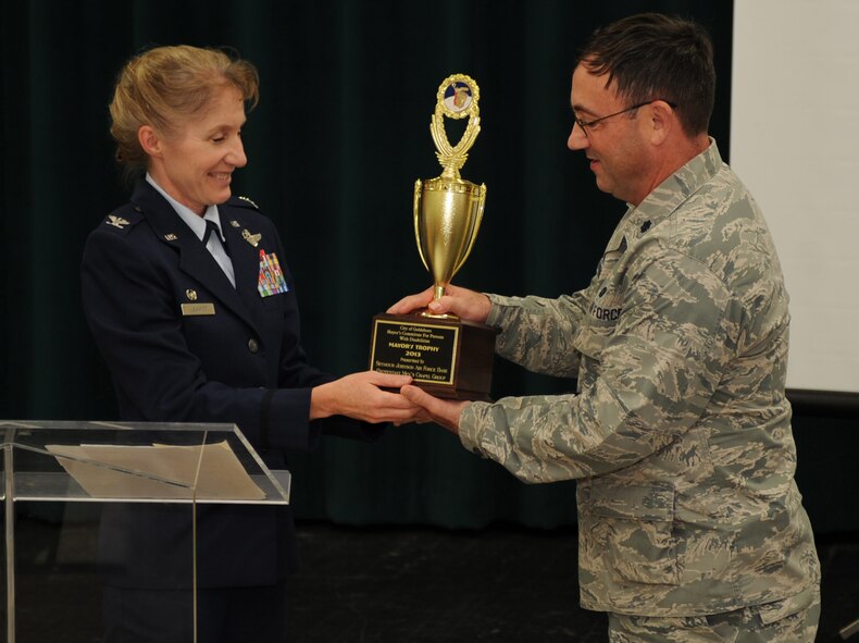 U.S. Air Force Chaplain (Lt. Col.) Dwayne Keener, 4th Fighter Wing head chaplain, accepts the Mayor’s Trophy from Col. Jeannie Leavitt, 4th FW commander, during the Mayor’s Person with Disabilities Annual Ceremony in Goldsboro, N.C., Oct. 17, 2013. The trophy was awarded to the Seymour Johnson Air Force Base Protestant Men’s Chapel Group for their efforts to increase the quality of life for persons with disabilities for more than 10 years. (U.S. Air Force photo by Tech. Sgt. Phillip Butterfield)