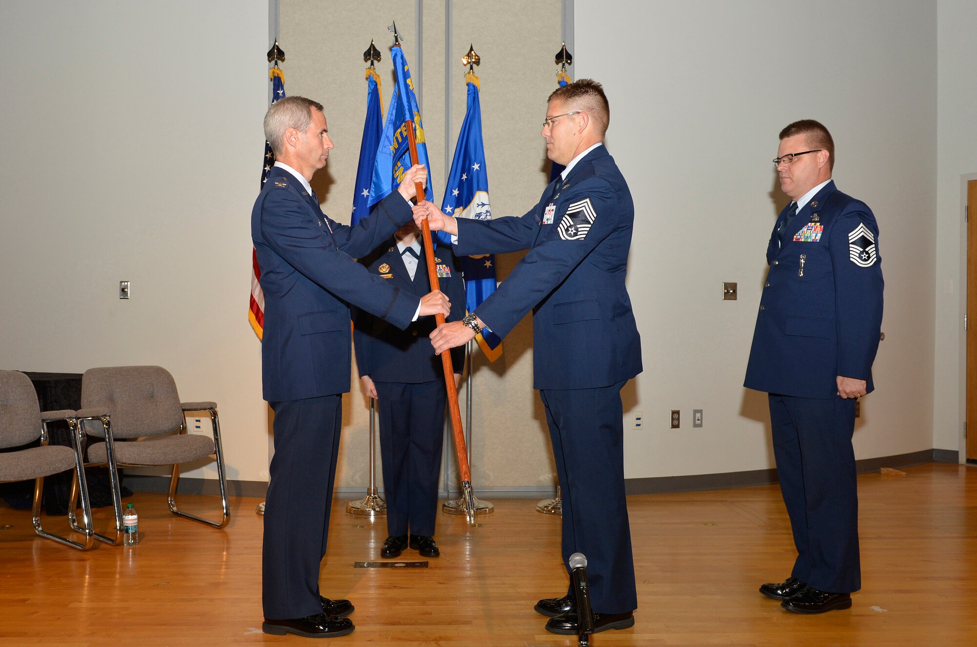 Col. Timothy Cathcart, commander of the I.G. Brown Training and Education Center (TEC), hands the guidon to Chief Master Sgt. Thomas K. Stoudt, who takes charge as the 13th commandant of the Paul H. Lankford Enlisted Professional Military Education Center here during a change of commandant ceremony Oct. 17 on the TEC campus at Spruance Hall. (U.S. Air National Guard photo by Master Sgt. Kurt Skoglund/Released)