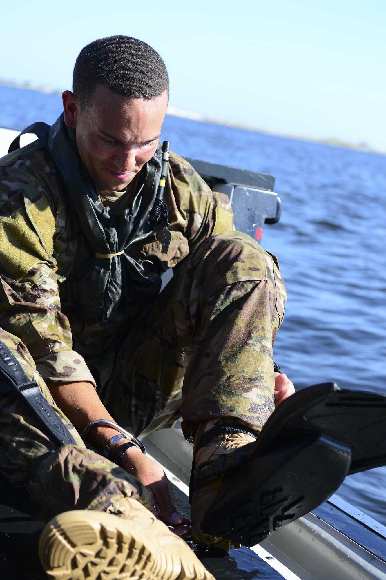 Staff Sgt. Johnnie Yellock Jr., a 23rd Special Tactics Squadron combat controller, removes his flippers after completing his final free fall jump before being medically retired Oct. 16, 2013, Hurlburt Field, Fla. Yellock endured 28 surgeries and two years of intense physical therapy to be able to walk again after his vehicle was struck by an improvised explosive device during a 2011 deployment to Afghanistan. (U.S. Air Force photo by Staff Sgt. John Bainter)