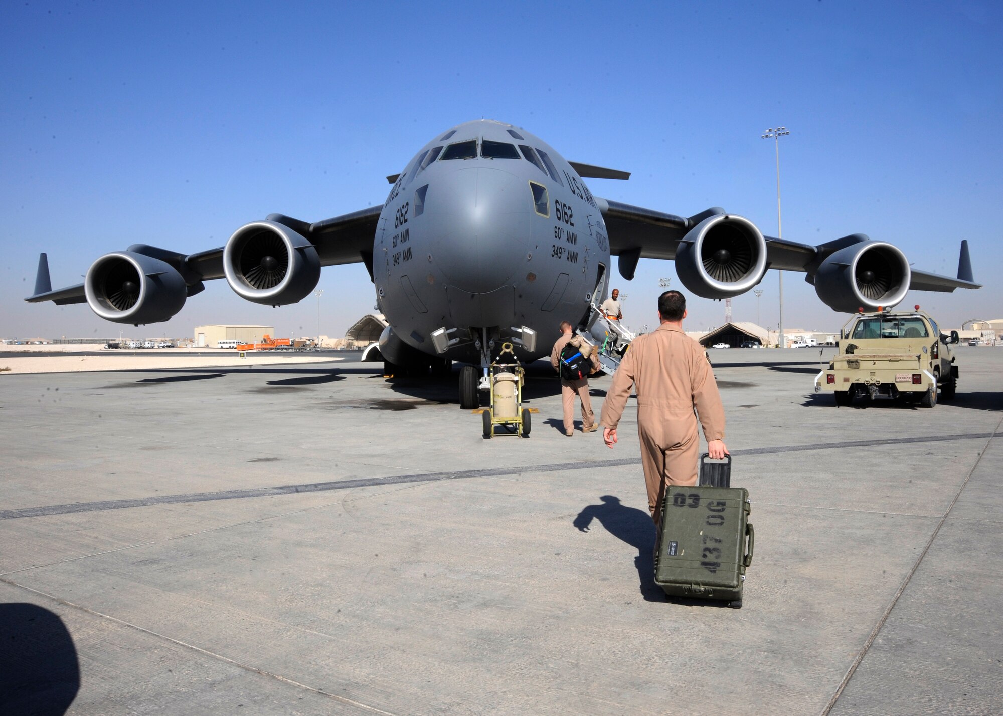 C-17 Globemaster III aircrew members walk toward their aircraft with equipment in-hand prior to a mission at the 379th Air Expeditionary Wing in Southwest Asia, Oct. 13, 2013. The Globemaster III is capable of rapid strategic delivery of troops and all types of cargo to main operating bases or directly to forward bases in the deployed locations. The C-17 crews assigned to the 816th Expeditionary Airlift Squadron are deployed from Joint Base Charleston, S.C. (U.S. Air Force photo/Senior Airman Bahja J. Jones) 