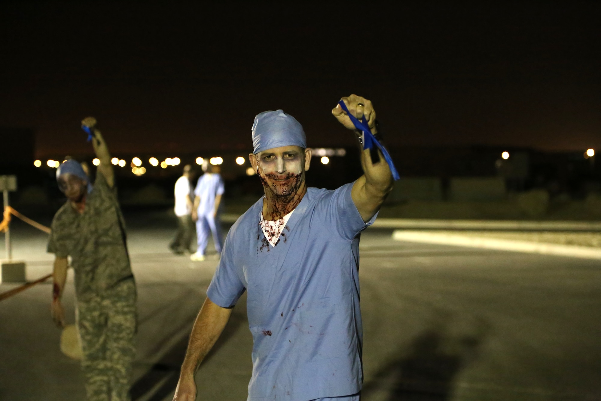 Chief Master Sgt. Gregory McNeill smiles after capturing a runner’s flag during a zombie run at the 379th Air Expeditionary Wing in Southwest Asia, Oct. 12, 2013. Runners were required to evade “zombies” and finish the race with both flags intact. The run was hosted by the Rising Six private organization to boost the morale of individuals on the base. McNeill is the 379th Expeditionary Medical Group superintendent here on a one-year remote tour and a native of Greenville, S.C. (U.S. Air Force photo/ Master Sgt. Dominic Neal)