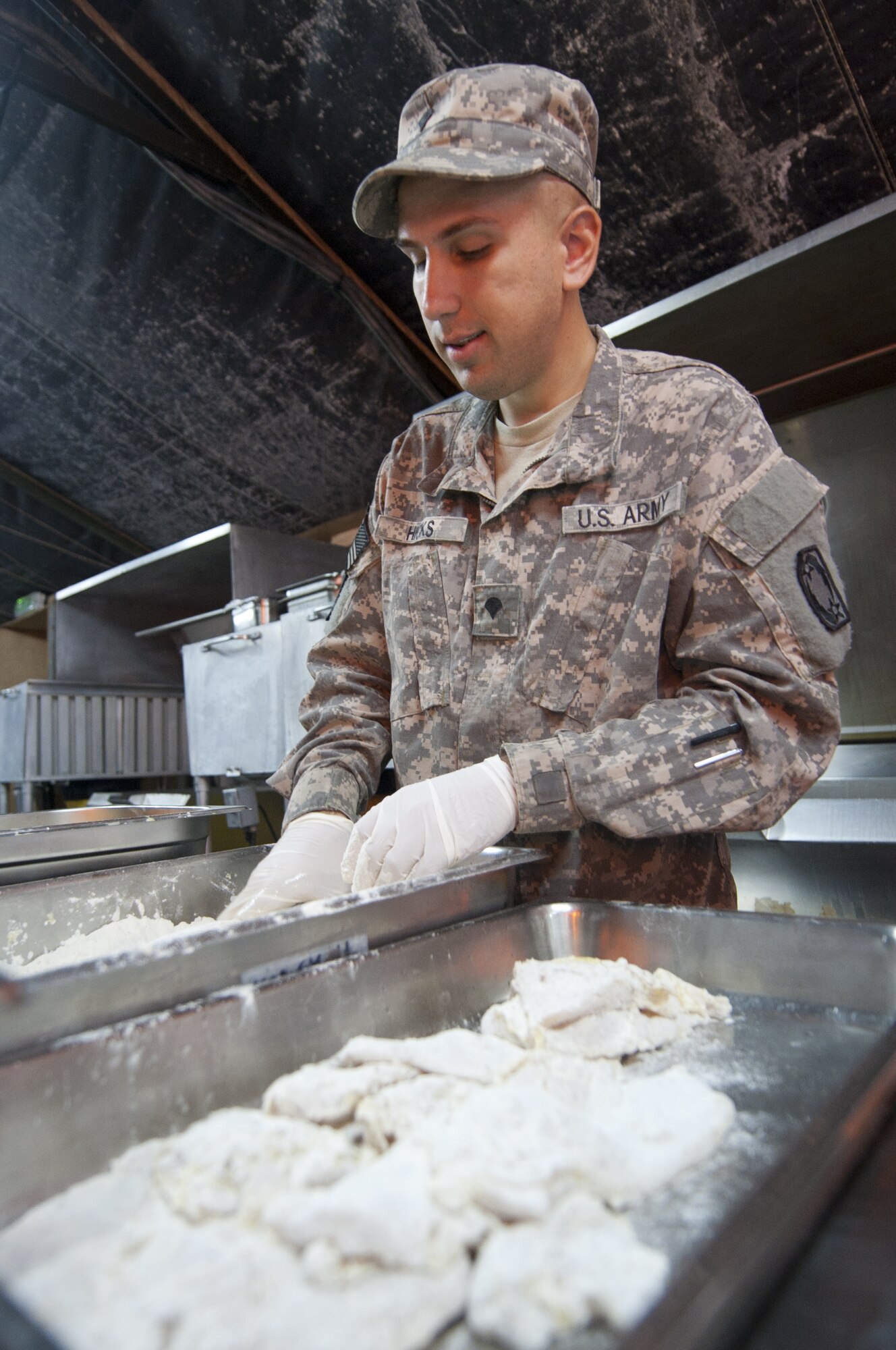 U.S. Army Spc. Nicholas Hicks, 1-62 Air Defense Artillery Battalion food service specialist, prepares parmesan chicken at Windy’s Dining Facility at an undisclosed location in Southwest Asia Oct. 8, 2013. At Windy’s, each food service specialist prepares a specialty meal each week from scratch. Hicks calls Long Beach, Miss., home and is deployed from Fort Hood, Texas. (U.S. Air Force photo by Staff Sgt. Jacob Morgan)