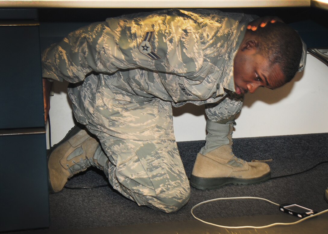 Members of the 107th and 914th Airlift Wing joined more than 18 million people world-wide in the Great ShakeOut earthquake drill at 10:17 am on October 17th, 2013.   Airman1st Class Michael Edwards, 107th Force Support Squadron, takes cover under his desk during the drill.  Members on base practiced as if there was a major earthquake occurring by using the Drop, Cover and Hold On method and stayed in position for a minute.  (New York Air National Guard/ Senior Master Sgt. Ray Lloyd)