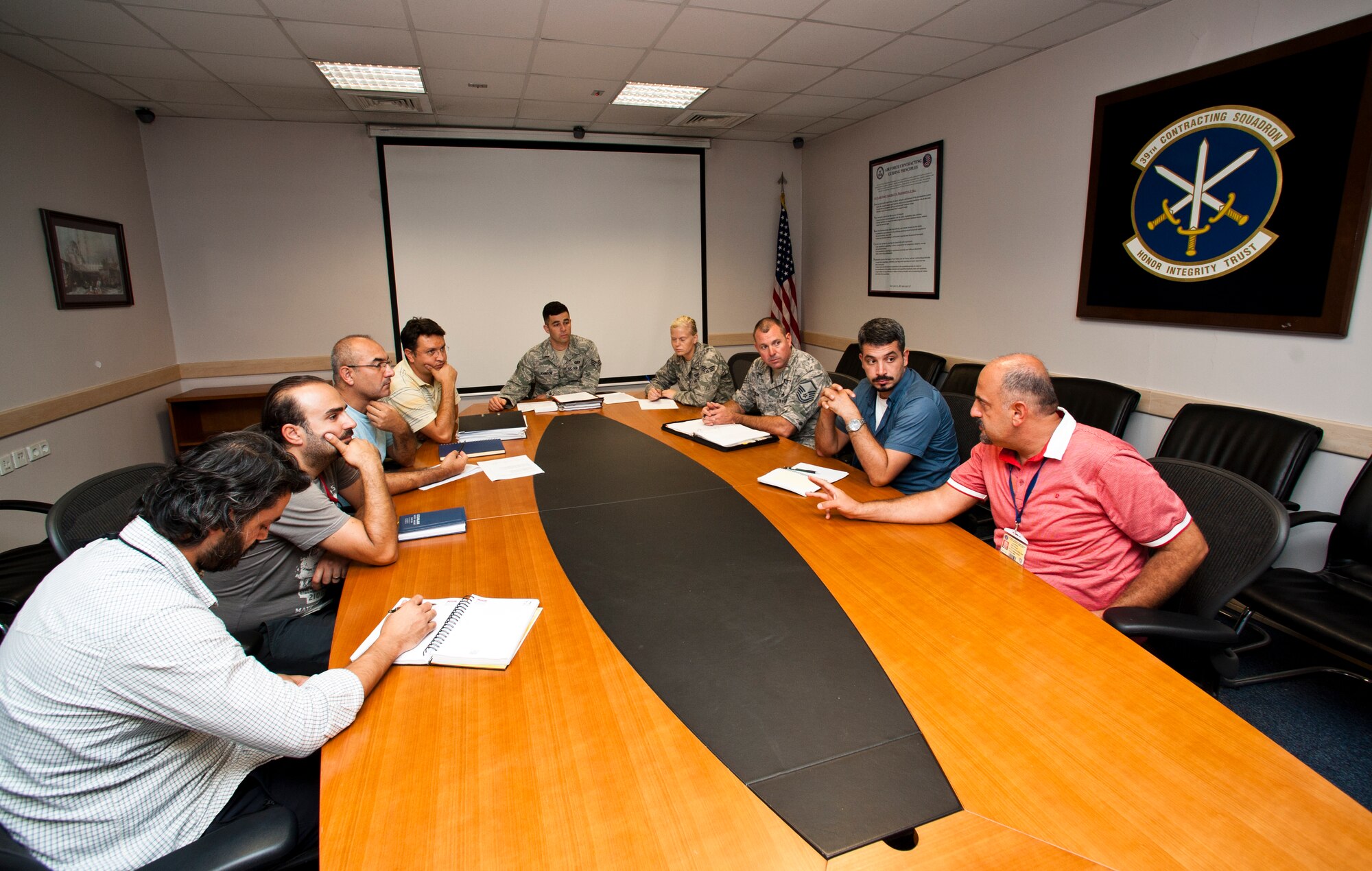 Members of the 39th Contracting Squadron gather for a meeting Sept. 19, 2013, at Incirlik Air Base, Turkey. Their flights prepare project packages for every contract on base. (U.S. Air Force photo by Senior Airman Daniel Phelps/Released)