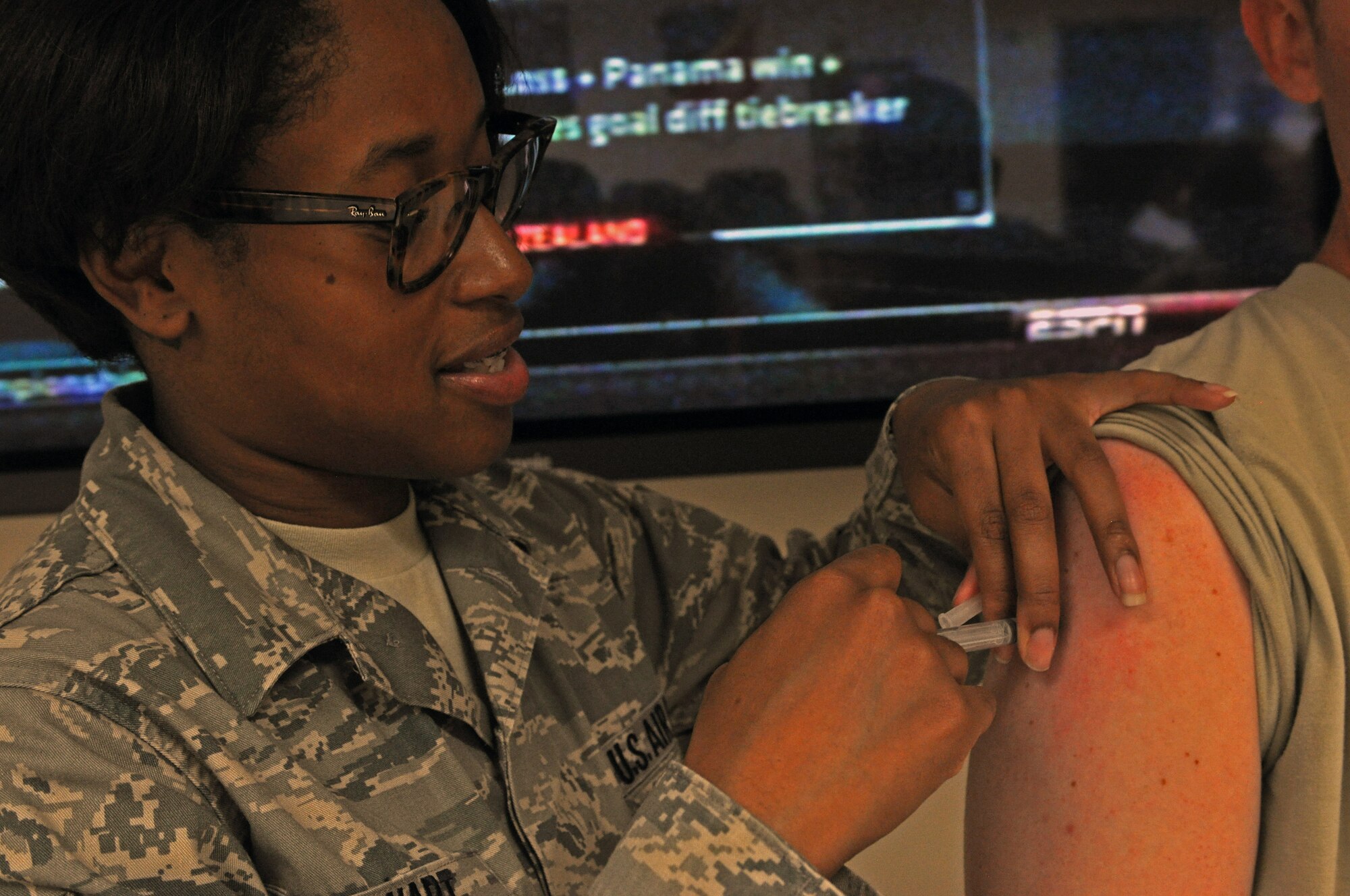 Staff Sgt. Shanika Stewart administers a flu shot at the 379 Air Expeditionary Wing in Southwest Asia, Oct. 15, 2013. Usually the flu season begins as early as October, peaks in the January/February timeframe, and can continue until May. Stewart is a medical technician with the 379th Expeditionary Medical Group deployed here from Offutt Air Force Base, Neb., and hails from Monterey, Calif. (U.S. Air Force photo/1st Lt. Susan Harrington)