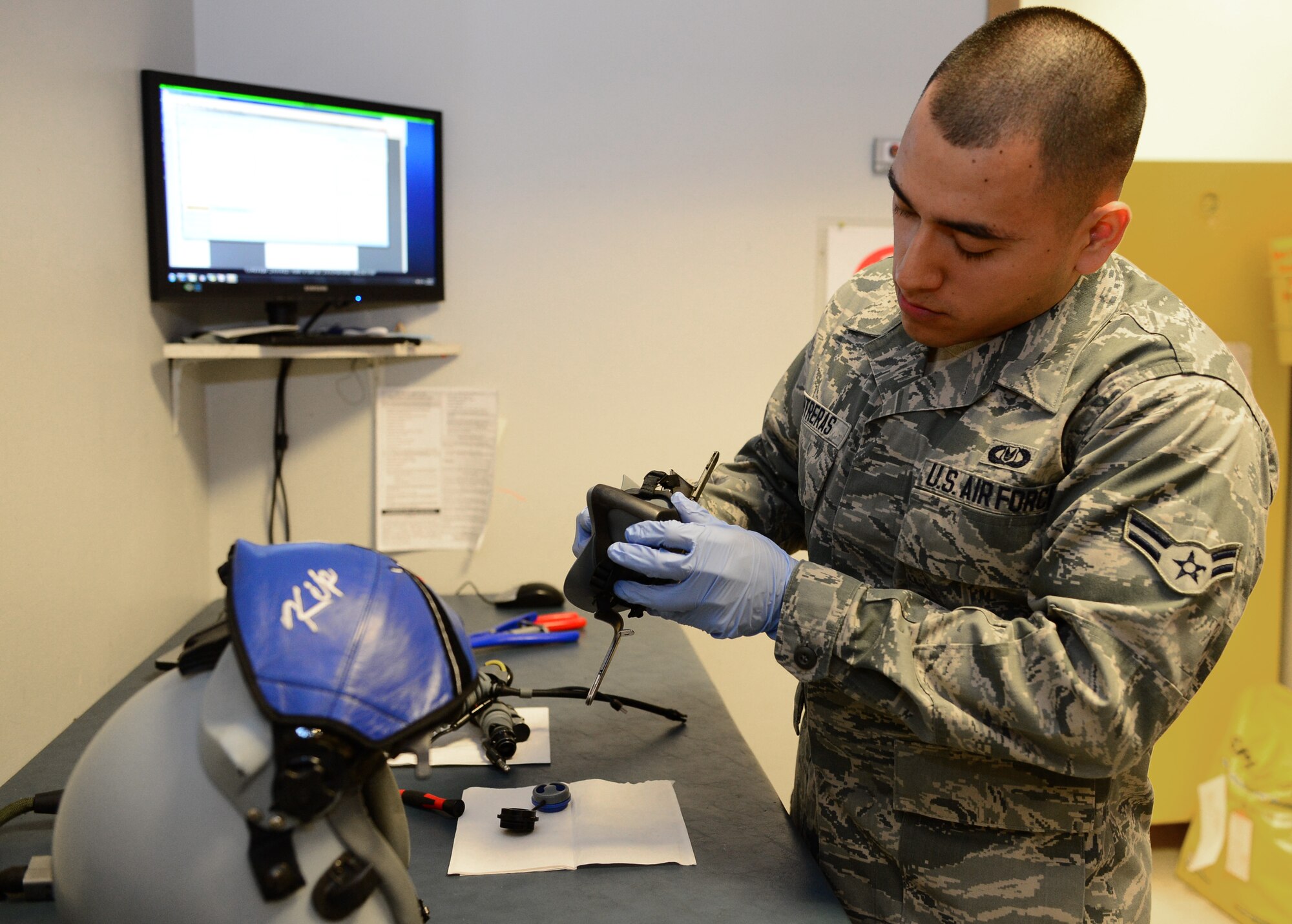 Airman 1st Class Roman Contreras, 48th Operations Support Squadron aircrew flight equipment apprentice, inspects an F-15 pilot helmet, at Royal Air Force Lakenheath, England, Oct. 17, 2013. Contreras was nominated for a Liberty Spotlight because he displays the core value of Excellence in All We Do. (U.S. Air Force photo by Airman 1st Class Dawn M. Weber/Released) 