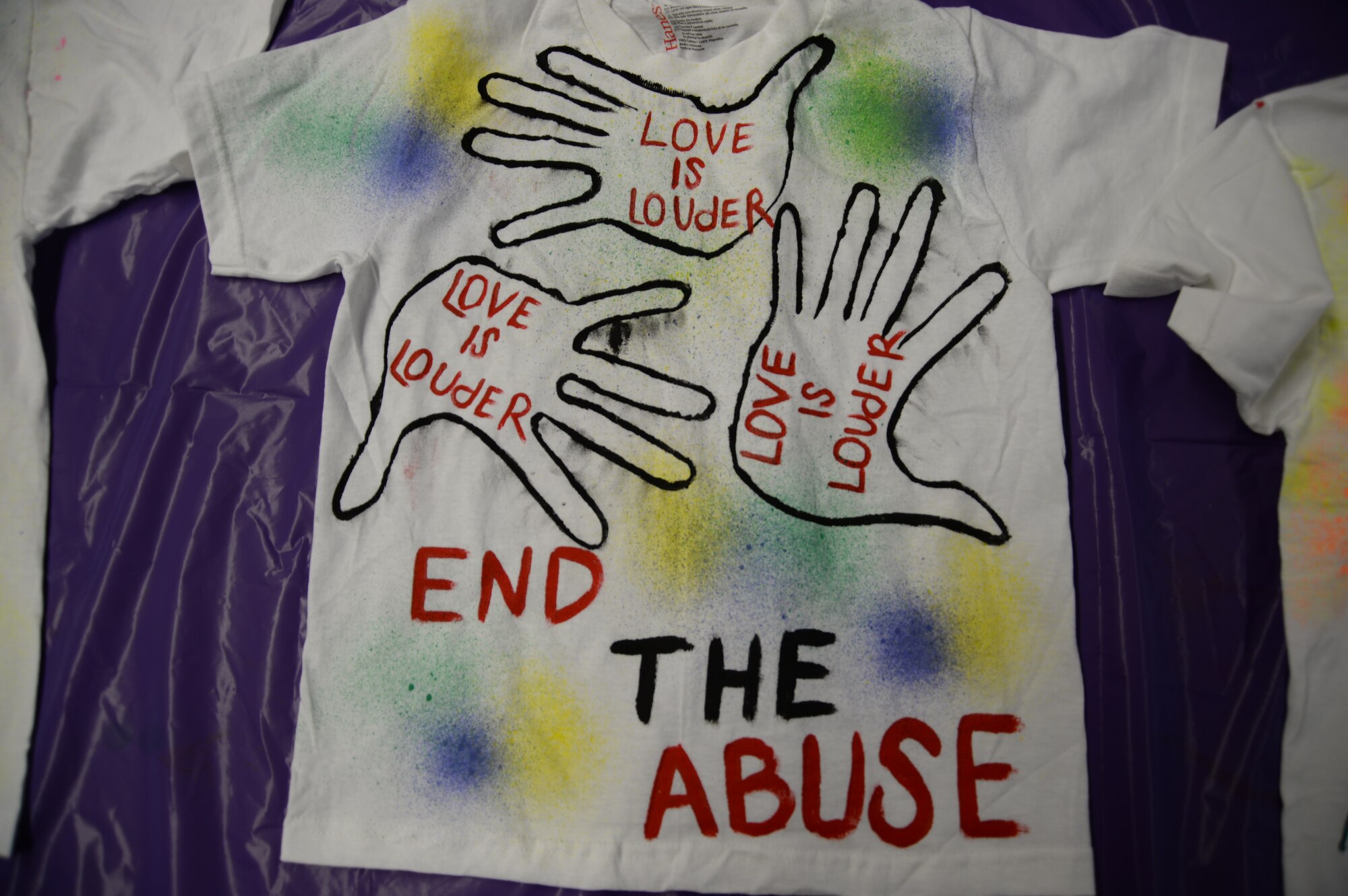 SPANGDAHLEM AIR BASE, Germany— A Saber team member displays a painted T-shirt with a message about domestic violence Oct. 17, 2013, for the Clothesline Project. This will be the eighth year the 52nd Medical Operations Squadron Family Advocacy office has put on this project, the T-shirt will be displayed along with many more Oct. 21-25 in front of the base post office to raise awareness of domestic violence. (U.S. Air Force photo by Airman 1st Class Dylan Nuckolls/Released)
