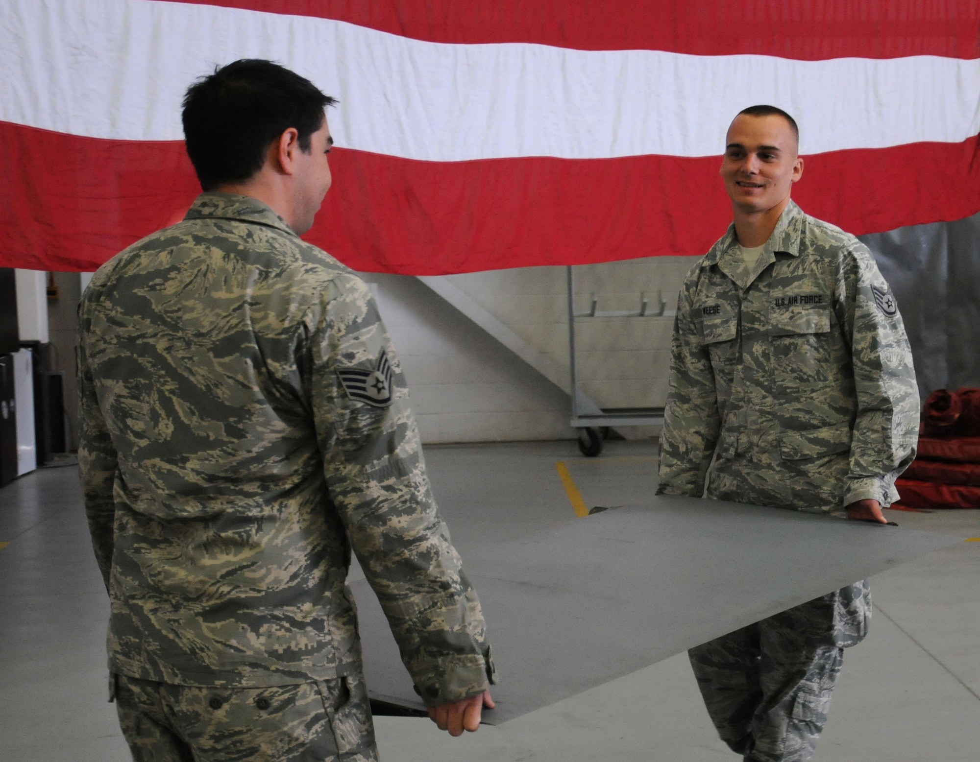 U.S. Air Force Staff Sgt. Adam Taylor, left, from Houston, Texas, and U.S. Air Force Staff Sgt. Joseph Weese, from Englewood, Fla., 100th Maintenance Squadron isochronal inspectors, carry a spoiler from the sheet metal shop back to an aircraft for installation Oct. 8, 2013, on RAF Mildenhall, England. The 100th MXS inspection section’s mission is to accomplish hourly post flight, periodic and 900-hour inspections on 15 KC-135R Stratotanker aircraft assigned to RAF Mildenhall. The shop’s service members wash and inspect the fleet for corrosion and carry out repairs found during the inspections. (U.S. Air Force photo by Gina Randall/Released) 