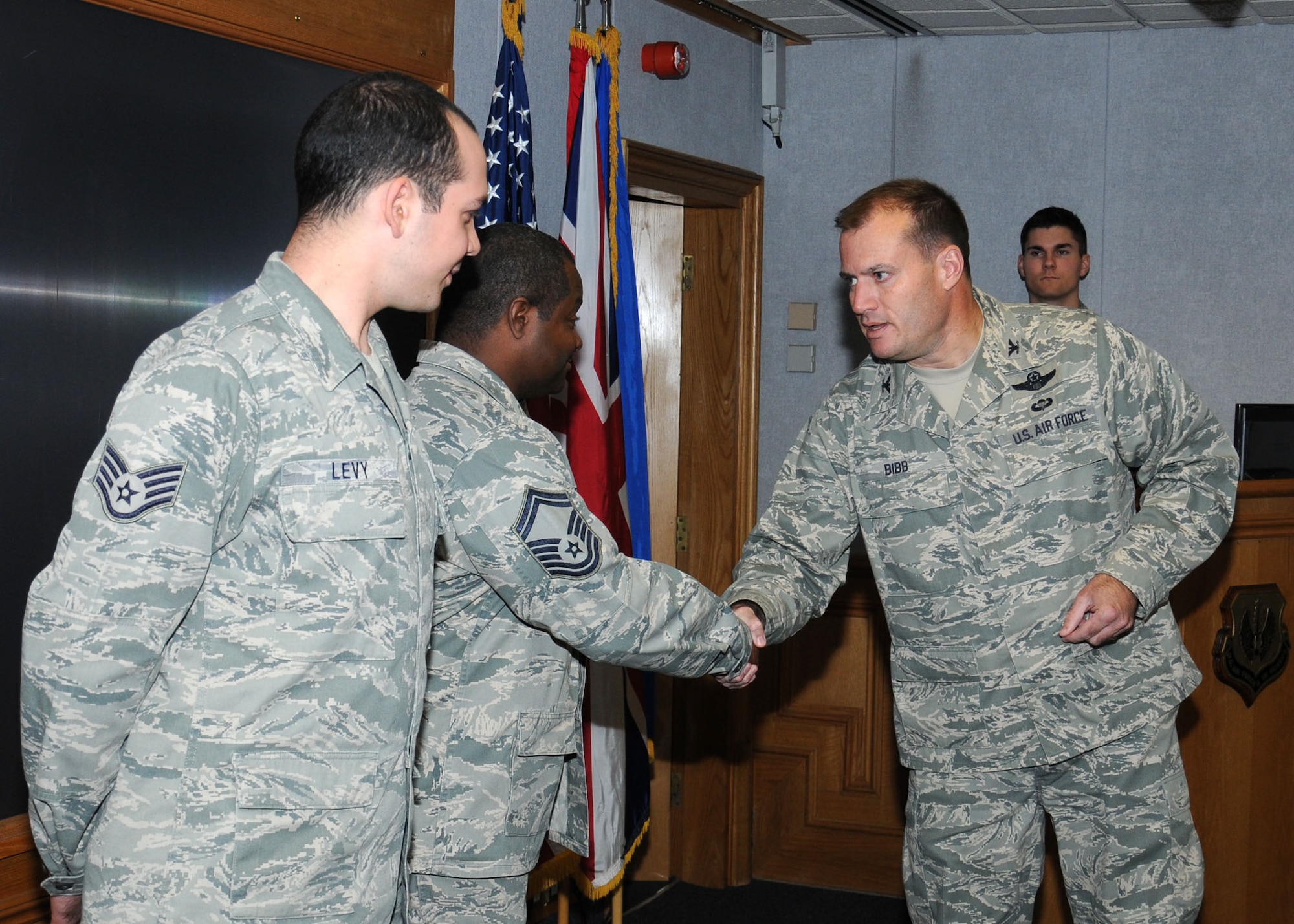 U.S. Air Force Col. Kenneth T. Bibb Jr., right, 100th Air Refueling Wing commander, congratulates U.S. Air Force Senior Master Sgt. Cornelious Thompson, center, 100th Operations Support Squadron airfield manager from Copperas Cove, Texas, and Staff Sgt. Elad Levy, 100th Logistics Readiness Squadron traffic management craftsman from Claremont, Calif., for organizing the September POW/MIA remembrance events Oct. 16, 2013, on RAF Mildenhall, England. Thompson and Levy were the chairman and vice chairman for the POW/MIA committee. They organized many events to remember those lost including a run, luncheon and motorcycle ride. They closed the events with a 24-hour vigil and a retreat ceremony where the U.S. flag was lowered and presented to a member of 100th ARW leadership. (U.S. Air Force photo by Gina Randall/Released)