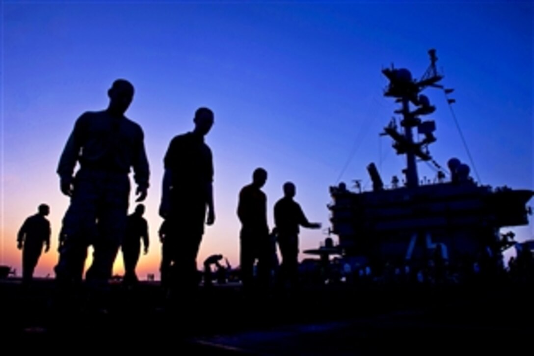 U.S. sailors and Marines check for damage on the flight deck of the aircraft carrier USS Harry S. Truman in the Gulf Ocean, Oct. 17, 2013. The Truman, flagship for the Harry S. Truman Carrier Strike Group, is deployed to the U.S. 5th Fleet area of responsibility to conduct maritime security operations and support theater security cooperation efforts.
