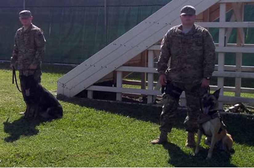 U.S. Navy Master at Arms Petty Officer 3rd Class Ryan Jarnberg and Master at Arms Petty Officer Third Class Tyler Drinski are part of a uniquely diverse team within the Joint Task Force-Bravo JSF K-9 unit.  The members of the Joint Task Force-Bravo Joint Security Forces K-9 unit represent three branches of service.  The K-9 unit consists of members of the U.S. Army, the U.S. Navy, and the U.S. Air Force.  (Photo by U.S. Army Sgt. Dionny Betancourt)