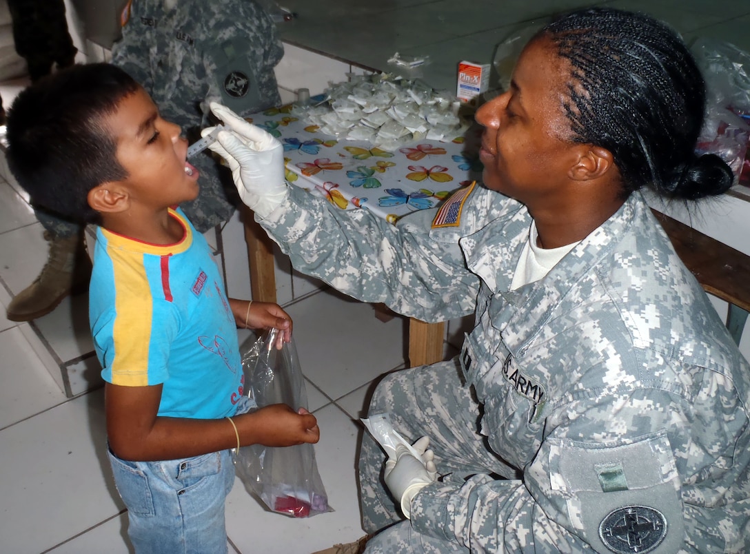 U.S. Army Capt. Maketta King provides medication to a young Honduran boy during a Medical Readiness Training Exercise (MEDRETE) in the Department of Comayagua, Honduras, Oct. 17, 2013.  Joint Task Force-Bravo partnered with the Honduran Ministry of Health and the Honduran military to provide medical care to more than 900 people during the operation.  (Photo by U.S. Army Sgt. Courtney Kreft)