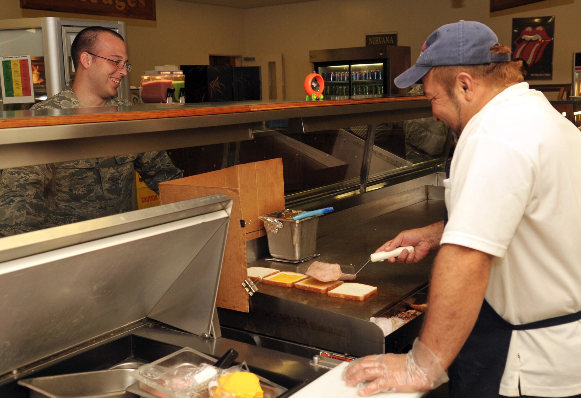 Tsuneyoshi Hanashiro, 18th Force Support Squadron cook, prepares a sandwich for U.S. Air Force Airman 1st Class Jason Lindsay, 718th Air Maintenance Squadron weapons maintainer, during lunch at the Marshall Dining Facility on Kadena Air Base, Japan, Oct. 17, 2013. The Marshall Dining Facility serves breakfast, lunch, and dinner, as well as a la carte menus and midnight meals. (U.S. Air Force photo by Naoto Anazawa)