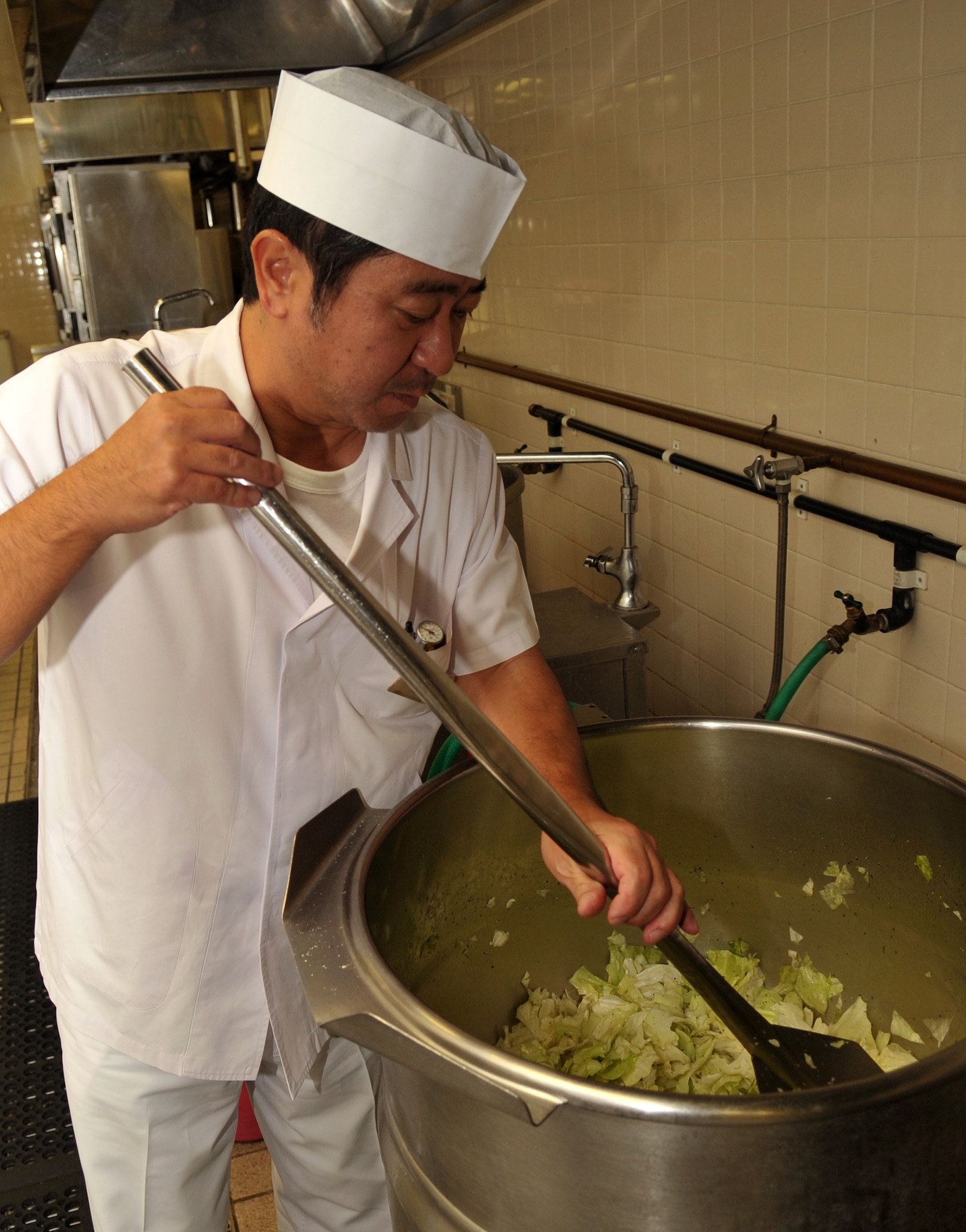 Toru Ishikawa, 18th Force Support Squadron cook, stirs up cabbage in preparation for lunch at the Marshall Dining Facility on Kadena Air Base, Japan, Oct. 17, 2013. The DFAC is open seven days a week and offers breakfast, lunch, dinner and midnight meals. (U.S. Air Force photo by Naoto Anazawa)