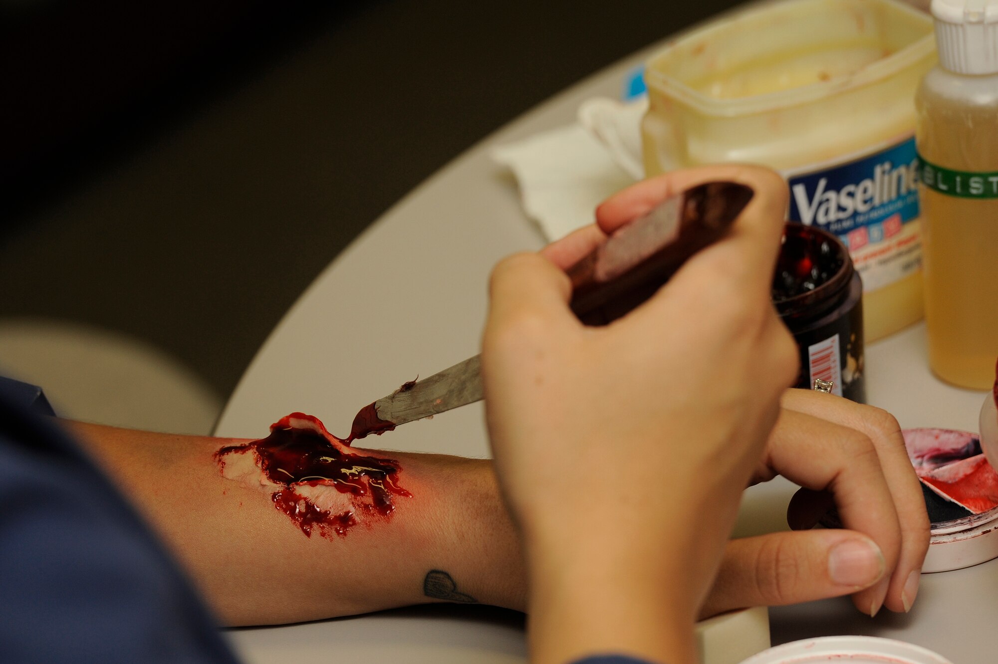 Airman 1st Class Alexandria Astorga, 18th Dental Squadron dental laboratory technician, practices applying moulage at Kadena Air Base, Japan, Oct. 17, 2013. The simulated wounds are made to look as realistic as possible to ensure personnel respond accurately when treating a victim. (U.S. Air Force photo by Senior Airman Marcus Morris)