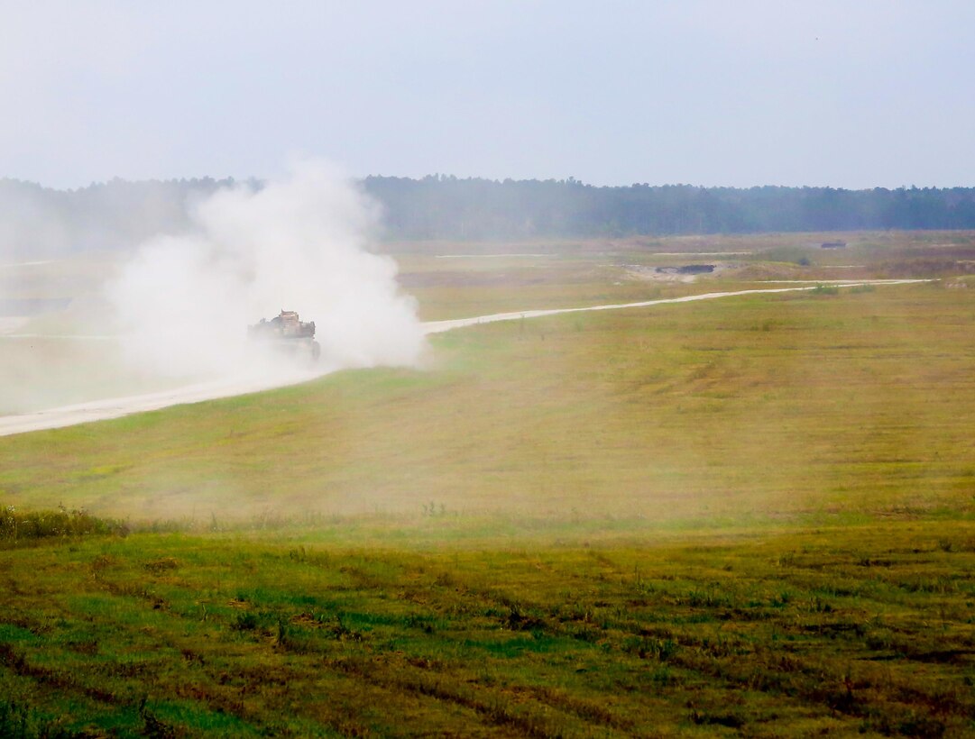 Smoke covers an M1A1 Abrams Main Battle Tank with 2nd Tank Battalion, 2nd Marine Division, after it fires the main gun at Range SR-10, during a training exercise with an RQ-11 Raven Unmanned Aerial Vehicle Oct. 15, 2013. The tank crews worked alongside scouts, who controlled the UAVs. The UAVs collected reconnaissance on the enemy and relayed the information to the tank crews before they attacked the objective.