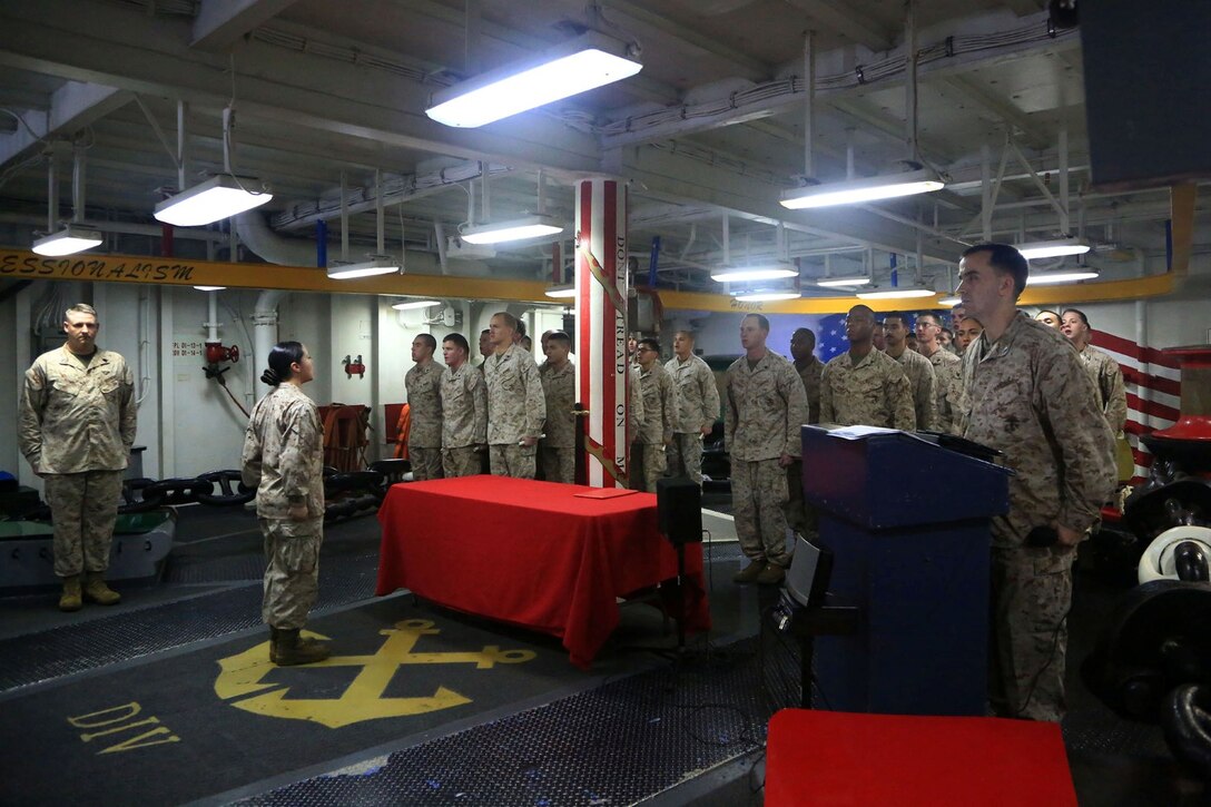 U.S. Marine corporals sing the Marines' Hymn during 13th Marine Expeditionary Unit's first corporals course graduation ceremony aboard the USS Boxer (LHD 4) Oct. 19, 2013. The 13th MEU is deployed with the Boxer Amphibious Ready Group as a theater reserve and crisis response force throughout the U.S. 5th Fleet area of responsibility. (U.S. Marine Corps Photo by Sgt. Jennifer Pirante/RELEASED)