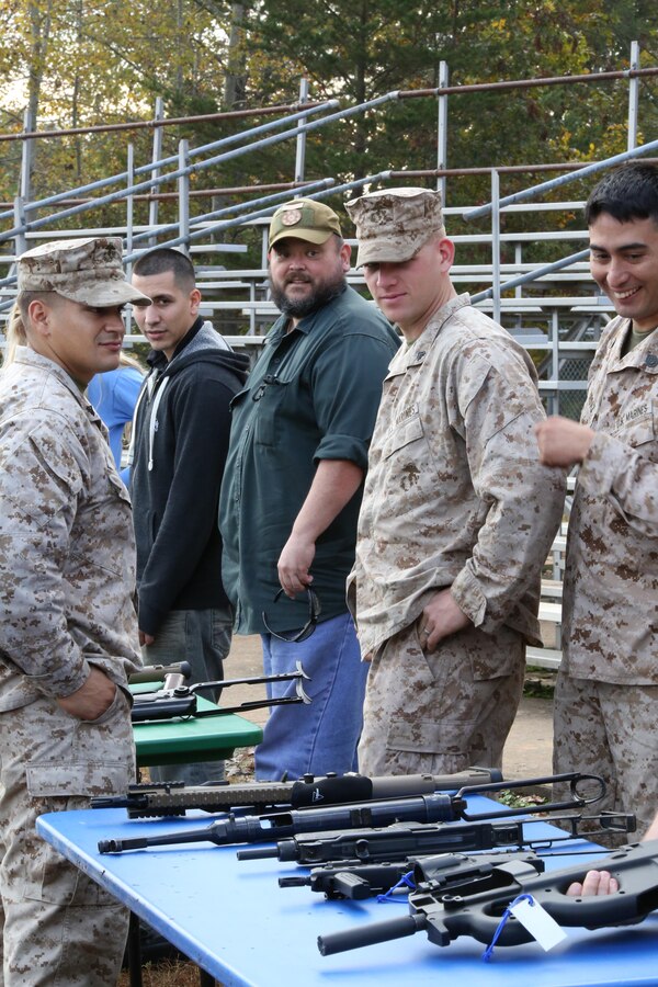 Marines and volunteers look over weapons before shooting them at Range 7 aboard Marine Corps Base Quantico on Oct. 17. 2013. More than 30 people participated in the event hosted by the FBI and Wounded Warrior Regiment.
