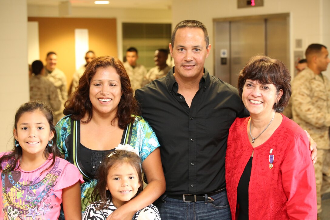 Family members of the late Master Sgt. Adam Benjamin pose for a picture during a dedication ceremony at Benjamin Hall aboard Weapons Training Bn. on Oct. 17, 2013. The new barracks was named after Benjamin who was killed while serving in Afghanistan in 2009.