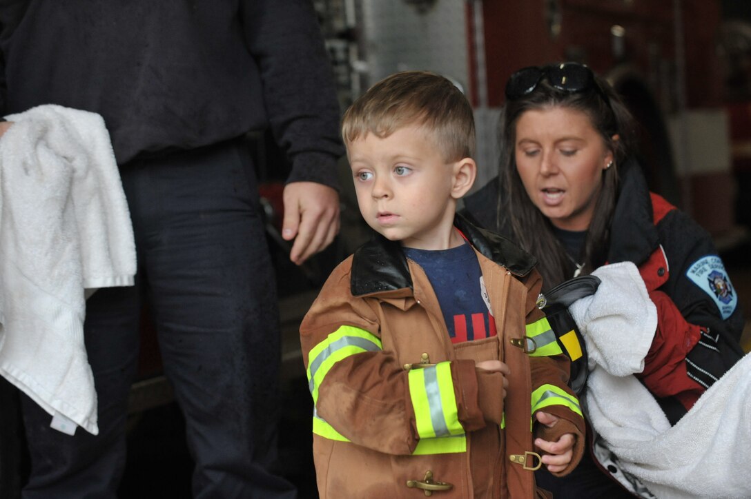 TJ removes his wet firefighting gear and prepares to enter the fire station and eat dinner on Oct. 10, 2013. TJ is a 3-year-old who has Langerhan cell histiocytosis. 