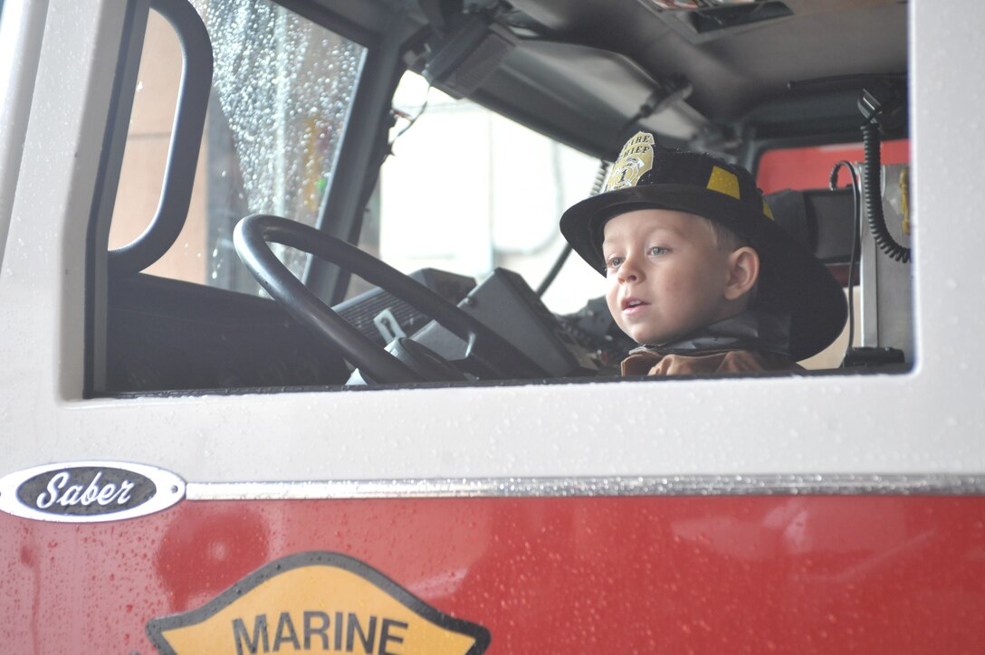 TJ sits on the front seat of a fire truck at Fire Station 533 while visiting the firefighters on Quantico Fire and Emergency Services on Oct. 10, 2013. TJ is a 3-year-old who has Langerhan cell histiocytosis