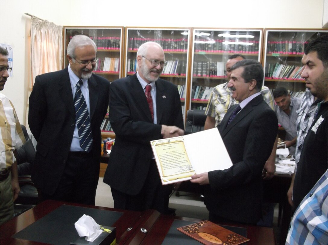 Andrew Snow, from the U.S. Embassy Baghdad's Economic Counselor Section, receives a letter of appreciation from Judge Jaffar Mosin at the handover ceremony. Courtesy photo.