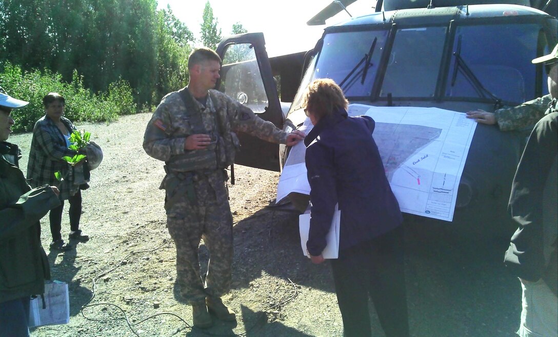 Maj. Eric Marcellus and Marcia Heer, project manager in the Regulatory Division, display a map on the front of a Sikorsky UH-60 Blackhawk helicopter near the village of Tyonek June 25. Marcellus and Capt. Robert Weakland are both civil engineers for the Alaska District and serve as aviators in the Alaska Army National Guard’s 1st Battalion, 207th Aviation Regiment. The pilots flew Corps personnel to visit the citizens of Tyonek and a potential site for a proposed coal mine. (Courtesy Photo)