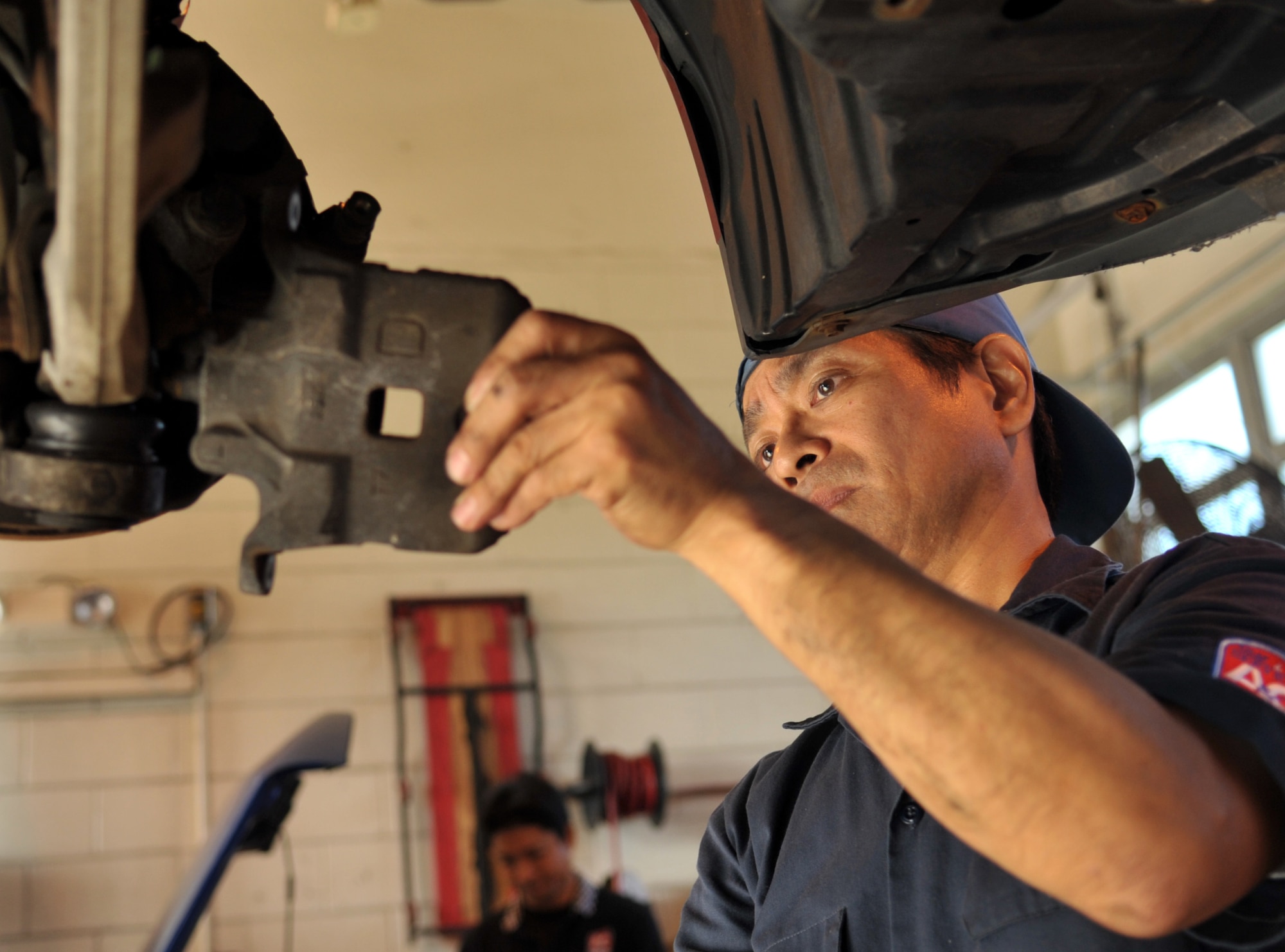 Satoshi Miyagi, auto hobby center mechanic, examines the wear of the brake pad at the auto hobby center on Kadena Air Base, Japan, Oct. 21, 2013. More than 10 U.S. contractors and seven local contractors repair and inspect cars for Kadena. (U.S. Air Force photo by Naoto Anazawa)

