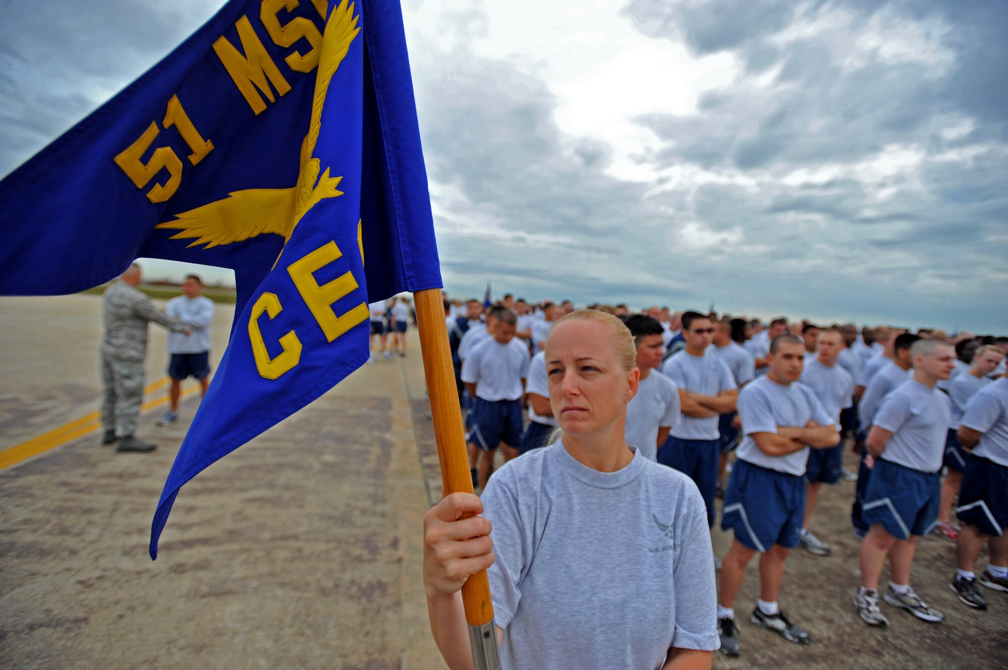 Senior Master Sgt. Tisha Gilmore, 51st  Civil Engineer Squadron first sergeant, holds the squadron guidon prior to a runway formation run on Osan Air Base, Oct. 4, 2013.  The 51st CES, along with more than 1,000 joint service personnel, participated in the run and a foreign object damage walk after construction of the 60-year-old runway was complete. (U.S. Air Force photo/Senior Airman Siuta B. Ika)