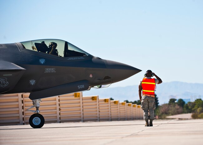Tech. Sgt. Jermaine Lee, 57th Aircraft Maintenance Squadron aerospace propulsion specialist, renders a salute to a pilot inside an F-35 Lightning II before a training mission Oct. 16, 2013, at Nellis Air Force Base, Nev. Refueling specialists and crew chiefs assigned to the 57th AMXS and 99th Logistics Readiness Squadron practice this procedure to keep their skills sharp and aid in the effort to provide combat-ready air power at a moment’s notice. (U.S. Air Force photo by Senior Airman Brett Clashman)