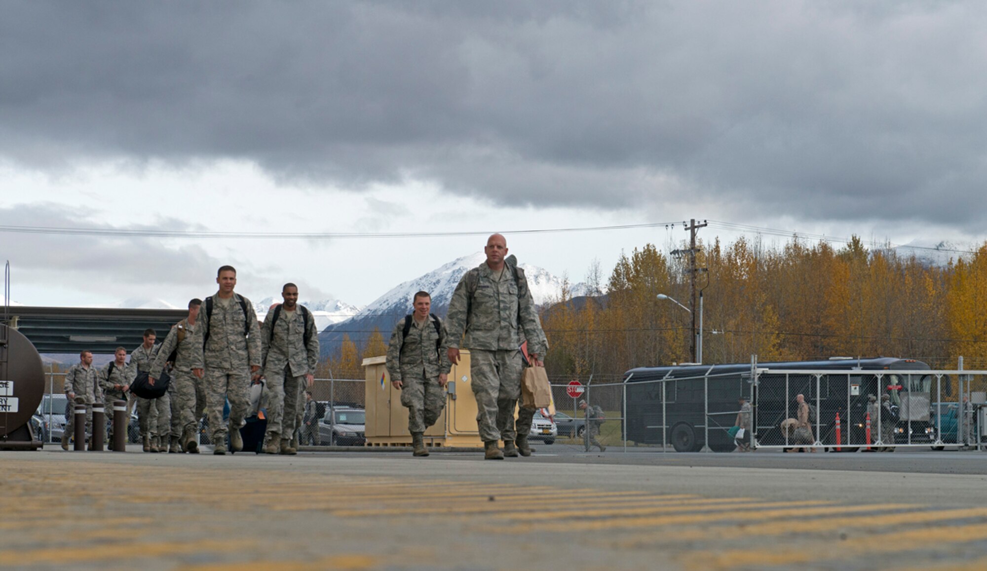 Airmen from the 90th Fighter Squadron and other 3rd Wing units get off a bus and walk to the 525th Fighter Squadron hangar where family and friends wait to welcome them home on Joint Base Elmendorf-Richardson, Oct. 7, 2013. They were deployed for five months and returned to friends and families in an emotional homecoming. (U.S. Air Force photo/Staff Sgt. Zachary Wolf)
