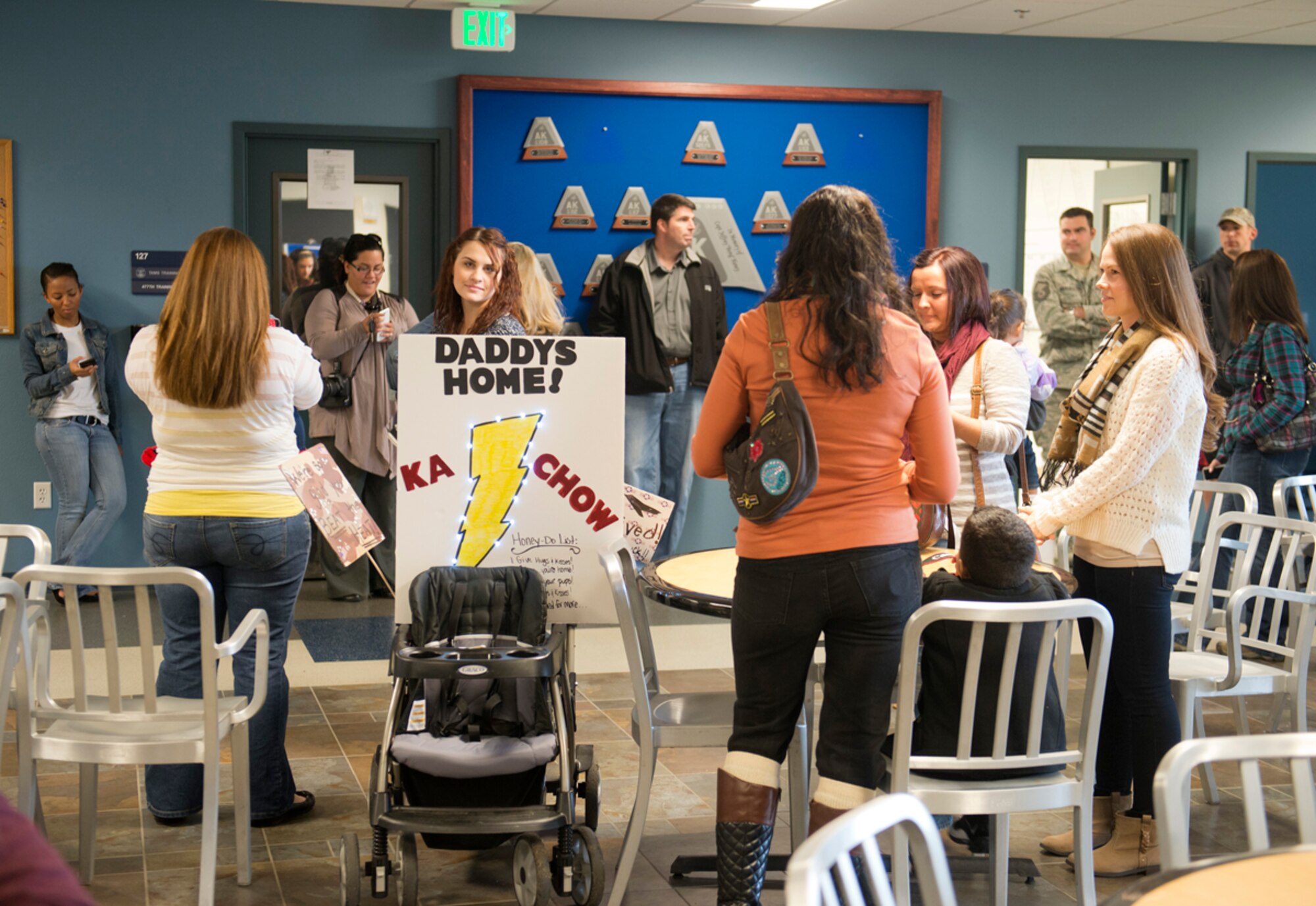 Family members wait inside the 525th Fighter Squadron's hangar for their loved ones to return on Joint Base Elmendorf-Richardson, Oct. 7. 2013. The service members were bussed back to the hangar where they met their families and friends before heading home after the five-month deployment. (U.S. Air Force photo/Staff Sgt. Zachary Wolf)