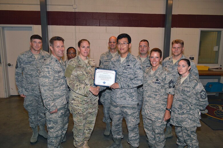 Master Sgt. Denise Knoll, 21st Special Tactics Squadron first sergeant, presents Airman 1st Class Hwansung Kim, 43d Logistics Readiness Squadron, with the Pope AAF First Sergeants’ Diamond Sharp Award on Aug 29, recognizing his outstanding innovation and leadership by creating the Wingmanship mobile app to assist fellow Pope Airmen and their families.  (U.S. Air Force photo/Marvin Krause)