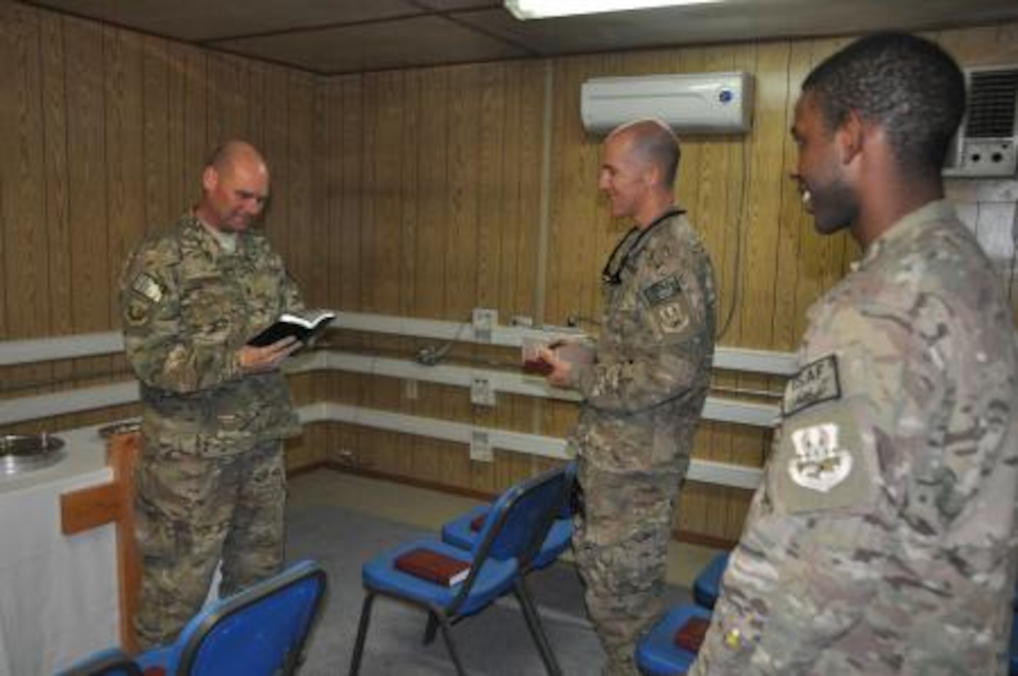 Chaplain (Maj.) Gary Coburn, 455th Air Expeditionary Wing deputy wing chaplain, speaks to Lt. Col. Daniel Hendrix, 41st Expeditionary Electronic Combat Squadron, and Senior Airman Jeremie Bumpers, 455th Expeditionary Maintenance Squadron, during a non-denominational Christian worship service at the Bagram Airfield flightline chapel Oct. 20, 2013. (U.S. Air Force photo/Tech. Sgt. Rob Hazelett)
