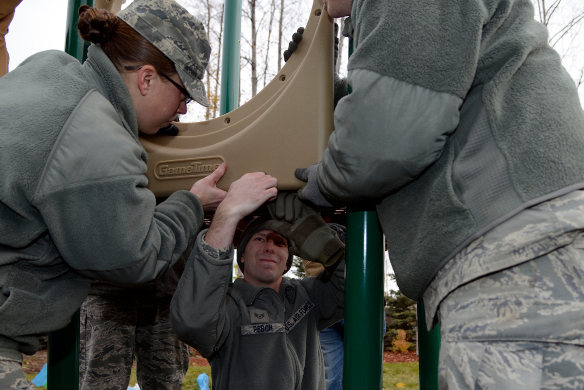 U.S. Air Force Staff Sgts. Martin Pesh (center) and Darcy Johnson, both assigned to the 611th Civil Engineer Squadron volunteers, put together a piece of the new playground at the Fisher House of Alaska, Joint Base Elmendorf-Richardson, Oct. 10. Since 1990, the Fisher House saved military, veterans and their families an estimated $200 million in out-of-pocket costs for lodging and transportation. (U.S. Air Force photo/Staff Sgt. Sheila deVera)