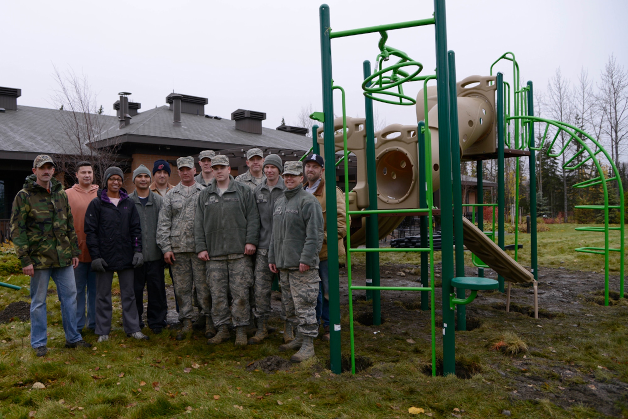 Members from the 611th Air Communications Squadron, 611th Air Support Squadron, and the 611th Civil Engineer Squadron, pose for the camera after dedicating more than 13 hours in the span of two days to assemble the new playground at the Fisher House of Alaska, Joint Base Elmendorf-Richardson, Oct. 10. The construction of the new playground was the latest investment from a 23-year partnership between the foundation and the military. (U.S. Air Force photo/Staff Sgt. Sheila deVera)