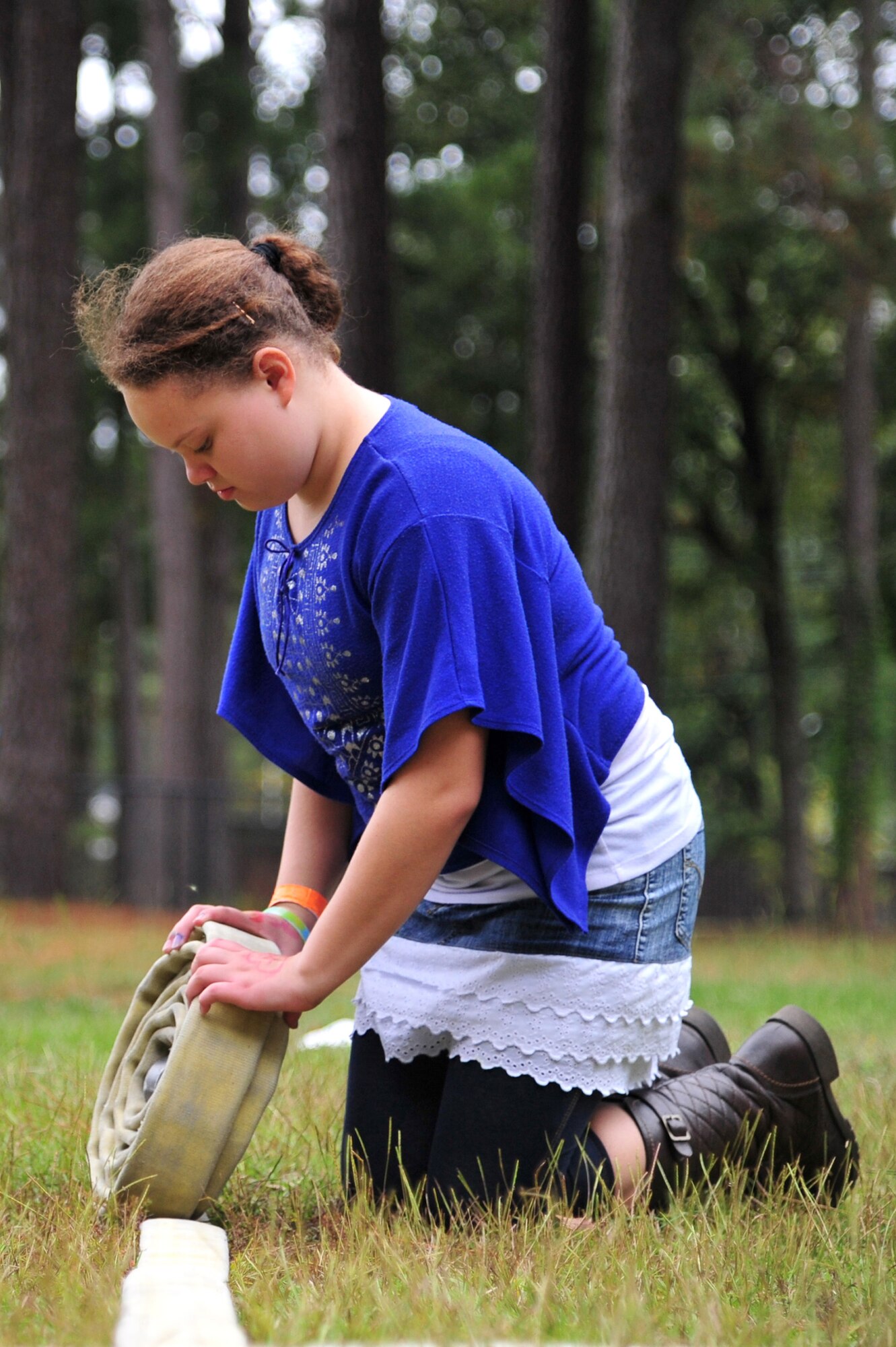 A child rolls a fire hose during a fire prevention week demonstration at Seymour Johnson Air Force Base, N.C., Oct. 16, 2013. Members of the 4th Civil Engineer Squadron fire department hosted activities at the youth center to show children what it’s like to be a firefighter and teach them about fire prevention. (U.S. Air Force photo by Senior Airman Mariah Tolbert) 