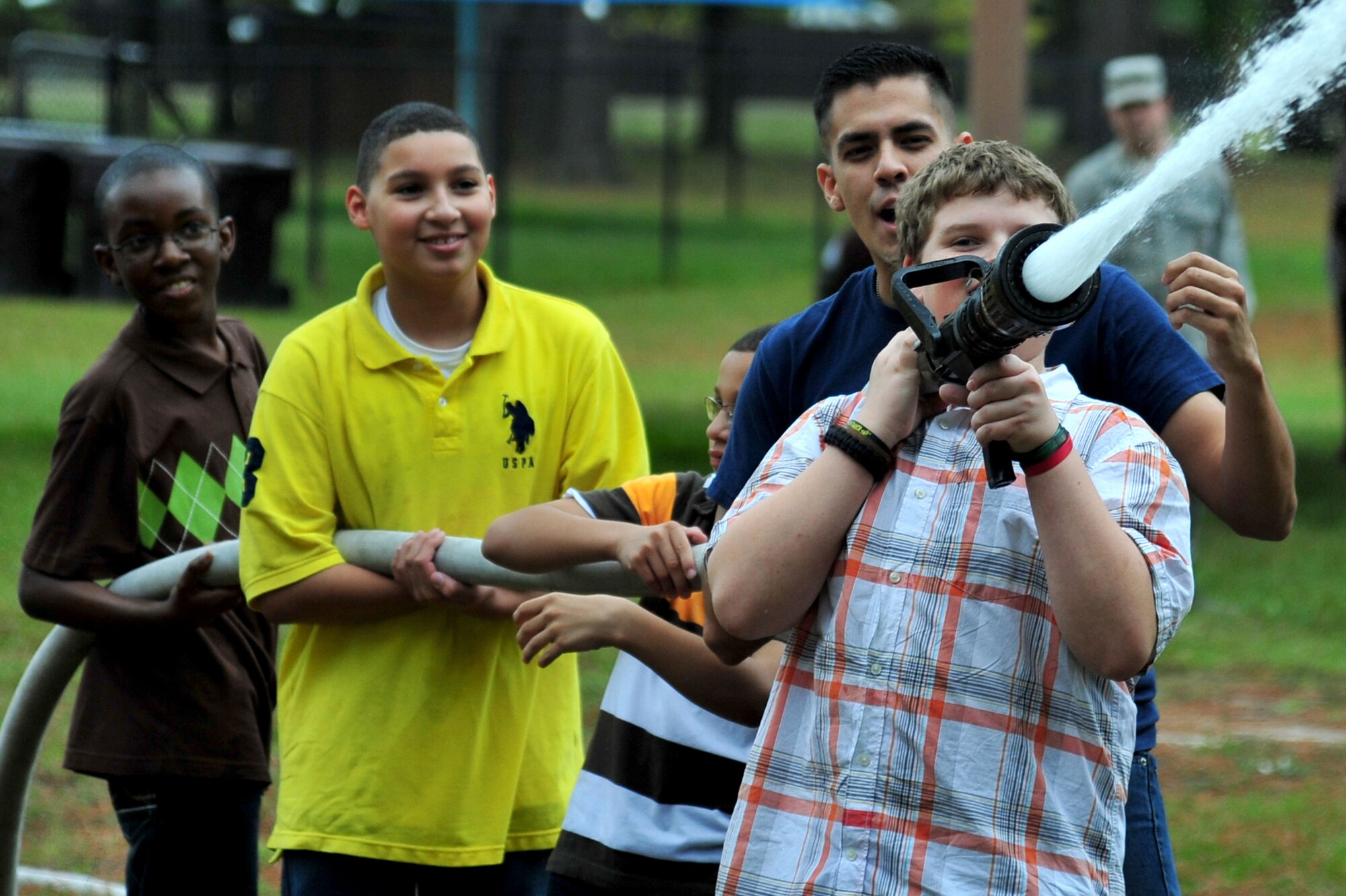 Children from the youth center learn how to use a fire hose during a Fire Prevention Week demonstration at Seymour Johnson Air Force Base, N.C., Oct. 16, 2013. Airmen from the 4th Civil Engineer Squadron fire department hosted the event to raise awareness and encourage fire prevention at every age. (U.S. Air Force photo by Senior Airman Mariah Tolbert)