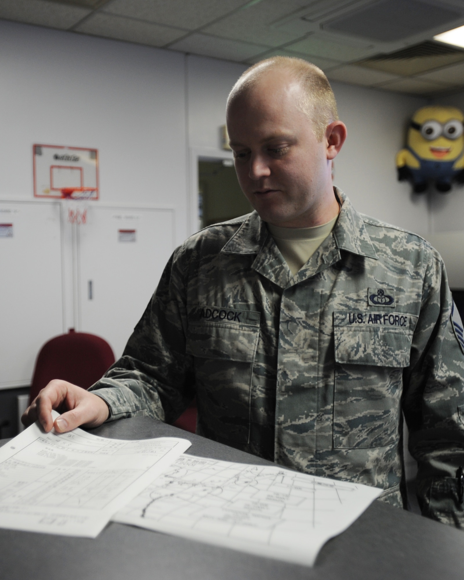 U.S. Air Force Master Sgt. Michael Adcock, 35th Operations Support Squadron weather flight chief, reviews paperwork during Typhoon Wipha Oct. 15, 2013, at Misawa Air Base, Japan. Member’s of the weather flight were able to observe the typhoon about a week out and were responsible for alerting base leadership on its progress. This task ties directly into their responsibility of tracking weather and issuing the proper watches and warnings to ensure base personnel and assets are prepared and safe. (U.S. Air Force photo/Staff Sgt. Alyssa C. Wallace)