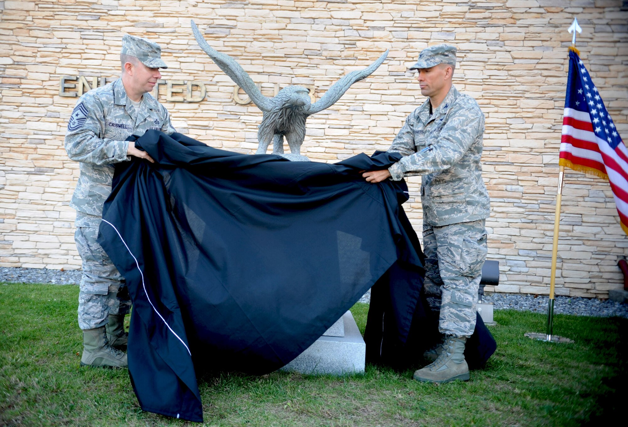 Col. Brook Leonard, 51st Fighter Wing commander, and Chief Master Sgt. Brendan Criswell, 51st FW command chief, unveil a statue dedicated to retired Master Sgt. Jim Price in front of the Osan Enlisted Club at Osan Air Base, Republic of Korea, Oct. 18, 2013. Price was a former Tuskegee Airman who lived in the Osan area and remained an active member of the community until he passed away in July 2012. (U.S. Air Force photo/Staff Sgt. Sara Csurilla)