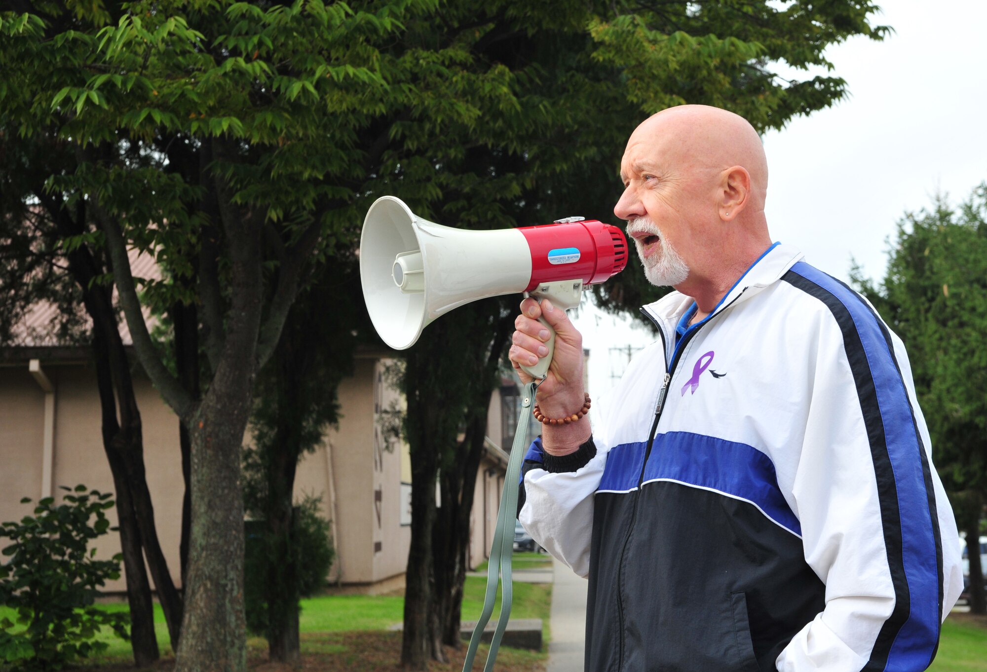 Carl Neighbors, 51st Medical Operations Squadron Family Advocacy intervention specialist, reminds runners of the reasons behind the Breast Cancer and Domestic Violence Awareness 5K at Osan Air Base, Republic of Korea, Oct. 19, 2013. Men, women and children of all ages gathered at the Fitness Center to show their support for finding a cure for breast cancer and ending domestic violence. (U.S. Air Force photo/Airman 1st Class Ashley J. Thum)