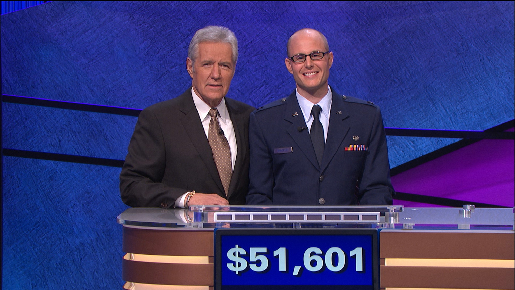 Capt. Stuart Anderson, 31st Judge Advocate chief of military justice, poses with Jeopardy host Alex Trebek during his appearance on quiz show Sept. 10, 2013. Overall, Anderson competed in four episodes winning a total $51,601. (Courtesy photo)