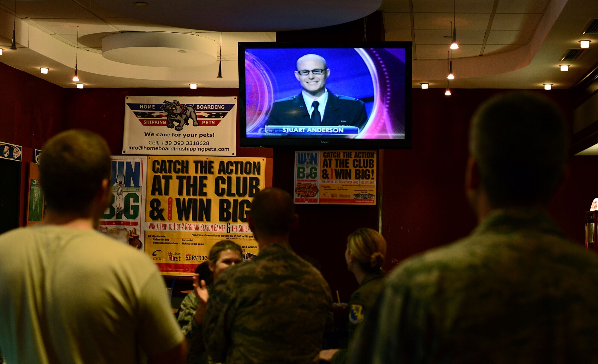 Members from Team Aviano cheer on Capt. Stuart Anderson, 31st Judge Advocate chief of military justice, during a viewing party at the La Bella Vista Club Oct. 15, 2013, at Aviano Air Base, Italy. Anderson originally auditioned for the American quiz show during a USO and Armed Forces Entertainment sponsored tour to Aviano Oct. 9, 2012 (U.S. Air Force photo/Senior Airman Michael Battles)