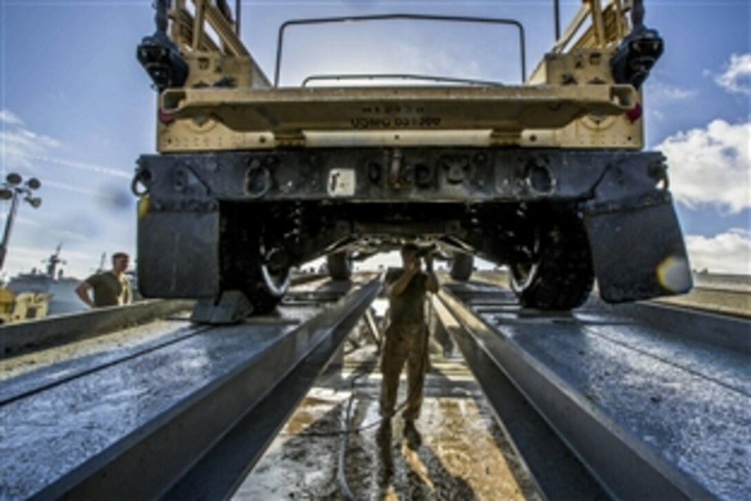 U.S. Marines rinse a Humvee before U.S. customs agents inspect it during the 26th Marine Expeditionary Unit’s wash down in Naval Station Rota, Spain, Oct. 19, 2013. The unit serves  as a sea-based, crisis-response force capable of conducting amphibious operations across the full range of military operations. 