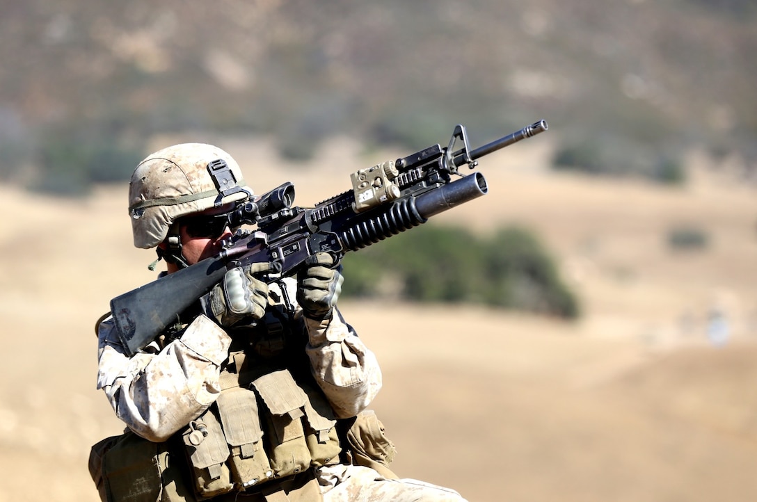 Corporal Clayton Thomas, squad leader, Lima Company, 3rd Battalion, 5th Marine Regiment, and a native of Coloma, Wis., repels mock enemy attacks with an M203 grenade launcher during an integrated exercise on Range 600 here, Oct. 15, 2013. The training helped Marines see how multiple elements of an attack work together to accomplish a single mission. The Marines also trained with light anti-armor weapons, M240 B medium machine guns and were supported by artillery fire. The exercise helped the Marines remain ready for any deployment.